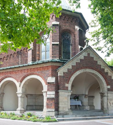 Zdjęcie nr 5: Kościół orientowany, murowany, trójnawowy, czteroprzęsłowy, z jednoprzęsłowym prezbiterium zakończonym wielobocznie. Do prezbiterium dostawione symetrycznie aneksy, od zachodu kruchta, w przyziemiu wieża flankowana dwiema klatkami schodowymi (pomieszczeniem gospodarczym?). Nawy oddzielone od siebie masywnymi filarami opilastrowanymi, z uproszczonymi kapitelami, podtrzymującymi arkady. Nawy i prezbiterium nakryte sklepieniem krzyżowym na gurtach, pięcioboczne zamknięcie prezbiterium sklepieniem parasolowatym. Nawę i prezbiterium oświetlają wysokie, prostokątne okna zakończone półkoliście z oknami trójrzędowymi dwuosiowymi, zakończonymi maswerkami. Układ komunikacyjny zaznaczony kamiennymi portalami o sfazowanych węgarach. Do kościoła prowadzą duże prostokątne drzwi, w kruchcie zakończone półkoliście. Tam też prostokątne wejścia do aneksów bocznych. W południowo-zachodniej ścianie prostokątne wejście zamknięte ściętym łukiem nadwieszonym. Takie samo wejście do aneksu południowego przy prezbiterium. Do aneksu północnego przy prezbiterium prostokątne wejście zamknięte łukiem odcinkowym, ujęte kamiennym portalem, zamkniętym półkoliście. Wejście w ścianie nawy południowej zaznaczone kamiennym portalem zamkniętym łukiem ostrym. W skrajnym przęśle nawy od zachodu chór muzyczny wsparty na dwóch filarach międzynawowych. W części chóru nad kruchtą wnęka otwarta kamienną rozetą. Fasada kościoła trójosiowa, dwukondygnacyjna, ujęta szkarpami z uskokami. Szkarpy z uskokami wydzielają także środkową oś fasady. W jej dolnej kondygnacji znajduje się kamienny portal główny, ujęty uskokowo ustawionymi półkolumnami i zakończony półkolistym tympanonem wypełnionym płaskorzeźbą ze sceną Zesłania Ducha Świętego. Powyżej wypełniona maswerkiem rozeta w profilowanej ramie. Między nią a biforium niewielki herb rodziny Potockich. Szczyt dekoruje fryz arkadkowy. W osiach bocznych wysokie, dwudzielne okna z maswerkiem. Budynek ustawiony na kamiennym cokole, oszkarpowany, z kamiennymi detalami, dekorowany fryzem arkadkowym, z otwartym od zewnątrz obejściem prezbiterium. W obejściu płaskorzeźbiona grupa Ukrzyżowania. Dachy kryte blachą – nawy i wieży dwuspadowe, przybudówek przy prezbiterium pulpitowe, nad obejściem i prezbiterium wieloboczne. Na kalenicy wieżyczka na sygnaturkę z latarnią i wielobocznym dachem. 