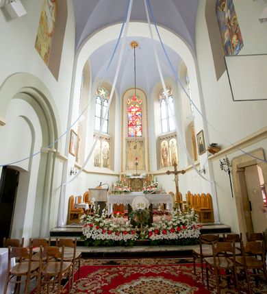 Zdjęcie nr 27: Kościół orientowany, murowany, trójnawowy, czteroprzęsłowy, z jednoprzęsłowym prezbiterium zakończonym wielobocznie. Do prezbiterium dostawione symetrycznie aneksy, od zachodu kruchta, w przyziemiu wieża flankowana dwiema klatkami schodowymi (pomieszczeniem gospodarczym?). Nawy oddzielone od siebie masywnymi filarami opilastrowanymi, z uproszczonymi kapitelami, podtrzymującymi arkady. Nawy i prezbiterium nakryte sklepieniem krzyżowym na gurtach, pięcioboczne zamknięcie prezbiterium sklepieniem parasolowatym. Nawę i prezbiterium oświetlają wysokie, prostokątne okna zakończone półkoliście z oknami trójrzędowymi dwuosiowymi, zakończonymi maswerkami. Układ komunikacyjny zaznaczony kamiennymi portalami o sfazowanych węgarach. Do kościoła prowadzą duże prostokątne drzwi, w kruchcie zakończone półkoliście. Tam też prostokątne wejścia do aneksów bocznych. W południowo-zachodniej ścianie prostokątne wejście zamknięte ściętym łukiem nadwieszonym. Takie samo wejście do aneksu południowego przy prezbiterium. Do aneksu północnego przy prezbiterium prostokątne wejście zamknięte łukiem odcinkowym, ujęte kamiennym portalem, zamkniętym półkoliście. Wejście w ścianie nawy południowej zaznaczone kamiennym portalem zamkniętym łukiem ostrym. W skrajnym przęśle nawy od zachodu chór muzyczny wsparty na dwóch filarach międzynawowych. W części chóru nad kruchtą wnęka otwarta kamienną rozetą. Fasada kościoła trójosiowa, dwukondygnacyjna, ujęta szkarpami z uskokami. Szkarpy z uskokami wydzielają także środkową oś fasady. W jej dolnej kondygnacji znajduje się kamienny portal główny, ujęty uskokowo ustawionymi półkolumnami i zakończony półkolistym tympanonem wypełnionym płaskorzeźbą ze sceną Zesłania Ducha Świętego. Powyżej wypełniona maswerkiem rozeta w profilowanej ramie. Między nią a biforium niewielki herb rodziny Potockich. Szczyt dekoruje fryz arkadkowy. W osiach bocznych wysokie, dwudzielne okna z maswerkiem. Budynek ustawiony na kamiennym cokole, oszkarpowany, z kamiennymi detalami, dekorowany fryzem arkadkowym, z otwartym od zewnątrz obejściem prezbiterium. W obejściu płaskorzeźbiona grupa Ukrzyżowania. Dachy kryte blachą – nawy i wieży dwuspadowe, przybudówek przy prezbiterium pulpitowe, nad obejściem i prezbiterium wieloboczne. Na kalenicy wieżyczka na sygnaturkę z latarnią i wielobocznym dachem. 