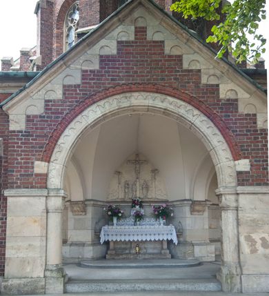 Zdjęcie nr 10: Kościół orientowany, murowany, trójnawowy, czteroprzęsłowy, z jednoprzęsłowym prezbiterium zakończonym wielobocznie. Do prezbiterium dostawione symetrycznie aneksy, od zachodu kruchta, w przyziemiu wieża flankowana dwiema klatkami schodowymi (pomieszczeniem gospodarczym?). Nawy oddzielone od siebie masywnymi filarami opilastrowanymi, z uproszczonymi kapitelami, podtrzymującymi arkady. Nawy i prezbiterium nakryte sklepieniem krzyżowym na gurtach, pięcioboczne zamknięcie prezbiterium sklepieniem parasolowatym. Nawę i prezbiterium oświetlają wysokie, prostokątne okna zakończone półkoliście z oknami trójrzędowymi dwuosiowymi, zakończonymi maswerkami. Układ komunikacyjny zaznaczony kamiennymi portalami o sfazowanych węgarach. Do kościoła prowadzą duże prostokątne drzwi, w kruchcie zakończone półkoliście. Tam też prostokątne wejścia do aneksów bocznych. W południowo-zachodniej ścianie prostokątne wejście zamknięte ściętym łukiem nadwieszonym. Takie samo wejście do aneksu południowego przy prezbiterium. Do aneksu północnego przy prezbiterium prostokątne wejście zamknięte łukiem odcinkowym, ujęte kamiennym portalem, zamkniętym półkoliście. Wejście w ścianie nawy południowej zaznaczone kamiennym portalem zamkniętym łukiem ostrym. W skrajnym przęśle nawy od zachodu chór muzyczny wsparty na dwóch filarach międzynawowych. W części chóru nad kruchtą wnęka otwarta kamienną rozetą. Fasada kościoła trójosiowa, dwukondygnacyjna, ujęta szkarpami z uskokami. Szkarpy z uskokami wydzielają także środkową oś fasady. W jej dolnej kondygnacji znajduje się kamienny portal główny, ujęty uskokowo ustawionymi półkolumnami i zakończony półkolistym tympanonem wypełnionym płaskorzeźbą ze sceną Zesłania Ducha Świętego. Powyżej wypełniona maswerkiem rozeta w profilowanej ramie. Między nią a biforium niewielki herb rodziny Potockich. Szczyt dekoruje fryz arkadkowy. W osiach bocznych wysokie, dwudzielne okna z maswerkiem. Budynek ustawiony na kamiennym cokole, oszkarpowany, z kamiennymi detalami, dekorowany fryzem arkadkowym, z otwartym od zewnątrz obejściem prezbiterium. W obejściu płaskorzeźbiona grupa Ukrzyżowania. Dachy kryte blachą – nawy i wieży dwuspadowe, przybudówek przy prezbiterium pulpitowe, nad obejściem i prezbiterium wieloboczne. Na kalenicy wieżyczka na sygnaturkę z latarnią i wielobocznym dachem. 