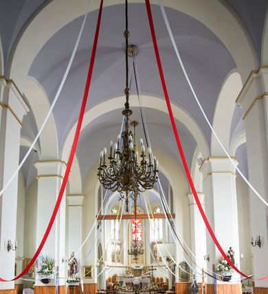 Zdjęcie nr 36: Kościół orientowany, murowany, trójnawowy, czteroprzęsłowy, z jednoprzęsłowym prezbiterium zakończonym wielobocznie. Do prezbiterium dostawione symetrycznie aneksy, od zachodu kruchta, w przyziemiu wieża flankowana dwiema klatkami schodowymi (pomieszczeniem gospodarczym?). Nawy oddzielone od siebie masywnymi filarami opilastrowanymi, z uproszczonymi kapitelami, podtrzymującymi arkady. Nawy i prezbiterium nakryte sklepieniem krzyżowym na gurtach, pięcioboczne zamknięcie prezbiterium sklepieniem parasolowatym. Nawę i prezbiterium oświetlają wysokie, prostokątne okna zakończone półkoliście z oknami trójrzędowymi dwuosiowymi, zakończonymi maswerkami. Układ komunikacyjny zaznaczony kamiennymi portalami o sfazowanych węgarach. Do kościoła prowadzą duże prostokątne drzwi, w kruchcie zakończone półkoliście. Tam też prostokątne wejścia do aneksów bocznych. W południowo-zachodniej ścianie prostokątne wejście zamknięte ściętym łukiem nadwieszonym. Takie samo wejście do aneksu południowego przy prezbiterium. Do aneksu północnego przy prezbiterium prostokątne wejście zamknięte łukiem odcinkowym, ujęte kamiennym portalem, zamkniętym półkoliście. Wejście w ścianie nawy południowej zaznaczone kamiennym portalem zamkniętym łukiem ostrym. W skrajnym przęśle nawy od zachodu chór muzyczny wsparty na dwóch filarach międzynawowych. W części chóru nad kruchtą wnęka otwarta kamienną rozetą. Fasada kościoła trójosiowa, dwukondygnacyjna, ujęta szkarpami z uskokami. Szkarpy z uskokami wydzielają także środkową oś fasady. W jej dolnej kondygnacji znajduje się kamienny portal główny, ujęty uskokowo ustawionymi półkolumnami i zakończony półkolistym tympanonem wypełnionym płaskorzeźbą ze sceną Zesłania Ducha Świętego. Powyżej wypełniona maswerkiem rozeta w profilowanej ramie. Między nią a biforium niewielki herb rodziny Potockich. Szczyt dekoruje fryz arkadkowy. W osiach bocznych wysokie, dwudzielne okna z maswerkiem. Budynek ustawiony na kamiennym cokole, oszkarpowany, z kamiennymi detalami, dekorowany fryzem arkadkowym, z otwartym od zewnątrz obejściem prezbiterium. W obejściu płaskorzeźbiona grupa Ukrzyżowania. Dachy kryte blachą – nawy i wieży dwuspadowe, przybudówek przy prezbiterium pulpitowe, nad obejściem i prezbiterium wieloboczne. Na kalenicy wieżyczka na sygnaturkę z latarnią i wielobocznym dachem. 