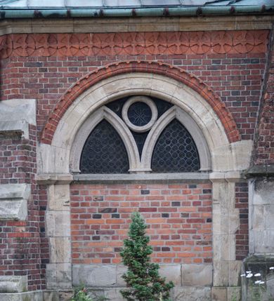 Zdjęcie nr 18: Kościół orientowany, murowany, trójnawowy, czteroprzęsłowy, z jednoprzęsłowym prezbiterium zakończonym wielobocznie. Do prezbiterium dostawione symetrycznie aneksy, od zachodu kruchta, w przyziemiu wieża flankowana dwiema klatkami schodowymi (pomieszczeniem gospodarczym?). Nawy oddzielone od siebie masywnymi filarami opilastrowanymi, z uproszczonymi kapitelami, podtrzymującymi arkady. Nawy i prezbiterium nakryte sklepieniem krzyżowym na gurtach, pięcioboczne zamknięcie prezbiterium sklepieniem parasolowatym. Nawę i prezbiterium oświetlają wysokie, prostokątne okna zakończone półkoliście z oknami trójrzędowymi dwuosiowymi, zakończonymi maswerkami. Układ komunikacyjny zaznaczony kamiennymi portalami o sfazowanych węgarach. Do kościoła prowadzą duże prostokątne drzwi, w kruchcie zakończone półkoliście. Tam też prostokątne wejścia do aneksów bocznych. W południowo-zachodniej ścianie prostokątne wejście zamknięte ściętym łukiem nadwieszonym. Takie samo wejście do aneksu południowego przy prezbiterium. Do aneksu północnego przy prezbiterium prostokątne wejście zamknięte łukiem odcinkowym, ujęte kamiennym portalem, zamkniętym półkoliście. Wejście w ścianie nawy południowej zaznaczone kamiennym portalem zamkniętym łukiem ostrym. W skrajnym przęśle nawy od zachodu chór muzyczny wsparty na dwóch filarach międzynawowych. W części chóru nad kruchtą wnęka otwarta kamienną rozetą. Fasada kościoła trójosiowa, dwukondygnacyjna, ujęta szkarpami z uskokami. Szkarpy z uskokami wydzielają także środkową oś fasady. W jej dolnej kondygnacji znajduje się kamienny portal główny, ujęty uskokowo ustawionymi półkolumnami i zakończony półkolistym tympanonem wypełnionym płaskorzeźbą ze sceną Zesłania Ducha Świętego. Powyżej wypełniona maswerkiem rozeta w profilowanej ramie. Między nią a biforium niewielki herb rodziny Potockich. Szczyt dekoruje fryz arkadkowy. W osiach bocznych wysokie, dwudzielne okna z maswerkiem. Budynek ustawiony na kamiennym cokole, oszkarpowany, z kamiennymi detalami, dekorowany fryzem arkadkowym, z otwartym od zewnątrz obejściem prezbiterium. W obejściu płaskorzeźbiona grupa Ukrzyżowania. Dachy kryte blachą – nawy i wieży dwuspadowe, przybudówek przy prezbiterium pulpitowe, nad obejściem i prezbiterium wieloboczne. Na kalenicy wieżyczka na sygnaturkę z latarnią i wielobocznym dachem. 