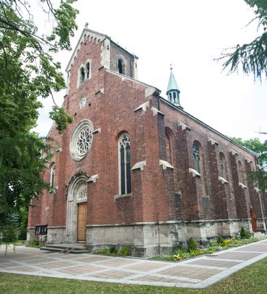 Zdjęcie nr 2: Kościół orientowany, murowany, trójnawowy, czteroprzęsłowy, z jednoprzęsłowym prezbiterium zakończonym wielobocznie. Do prezbiterium dostawione symetrycznie aneksy, od zachodu kruchta, w przyziemiu wieża flankowana dwiema klatkami schodowymi (pomieszczeniem gospodarczym?). Nawy oddzielone od siebie masywnymi filarami opilastrowanymi, z uproszczonymi kapitelami, podtrzymującymi arkady. Nawy i prezbiterium nakryte sklepieniem krzyżowym na gurtach, pięcioboczne zamknięcie prezbiterium sklepieniem parasolowatym. Nawę i prezbiterium oświetlają wysokie, prostokątne okna zakończone półkoliście z oknami trójrzędowymi dwuosiowymi, zakończonymi maswerkami. Układ komunikacyjny zaznaczony kamiennymi portalami o sfazowanych węgarach. Do kościoła prowadzą duże prostokątne drzwi, w kruchcie zakończone półkoliście. Tam też prostokątne wejścia do aneksów bocznych. W południowo-zachodniej ścianie prostokątne wejście zamknięte ściętym łukiem nadwieszonym. Takie samo wejście do aneksu południowego przy prezbiterium. Do aneksu północnego przy prezbiterium prostokątne wejście zamknięte łukiem odcinkowym, ujęte kamiennym portalem, zamkniętym półkoliście. Wejście w ścianie nawy południowej zaznaczone kamiennym portalem zamkniętym łukiem ostrym. W skrajnym przęśle nawy od zachodu chór muzyczny wsparty na dwóch filarach międzynawowych. W części chóru nad kruchtą wnęka otwarta kamienną rozetą. Fasada kościoła trójosiowa, dwukondygnacyjna, ujęta szkarpami z uskokami. Szkarpy z uskokami wydzielają także środkową oś fasady. W jej dolnej kondygnacji znajduje się kamienny portal główny, ujęty uskokowo ustawionymi półkolumnami i zakończony półkolistym tympanonem wypełnionym płaskorzeźbą ze sceną Zesłania Ducha Świętego. Powyżej wypełniona maswerkiem rozeta w profilowanej ramie. Między nią a biforium niewielki herb rodziny Potockich. Szczyt dekoruje fryz arkadkowy. W osiach bocznych wysokie, dwudzielne okna z maswerkiem. Budynek ustawiony na kamiennym cokole, oszkarpowany, z kamiennymi detalami, dekorowany fryzem arkadkowym, z otwartym od zewnątrz obejściem prezbiterium. W obejściu płaskorzeźbiona grupa Ukrzyżowania. Dachy kryte blachą – nawy i wieży dwuspadowe, przybudówek przy prezbiterium pulpitowe, nad obejściem i prezbiterium wieloboczne. Na kalenicy wieżyczka na sygnaturkę z latarnią i wielobocznym dachem. 