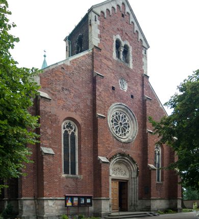 Zdjęcie nr 4: Kościół orientowany, murowany, trójnawowy, czteroprzęsłowy, z jednoprzęsłowym prezbiterium zakończonym wielobocznie. Do prezbiterium dostawione symetrycznie aneksy, od zachodu kruchta, w przyziemiu wieża flankowana dwiema klatkami schodowymi (pomieszczeniem gospodarczym?). Nawy oddzielone od siebie masywnymi filarami opilastrowanymi, z uproszczonymi kapitelami, podtrzymującymi arkady. Nawy i prezbiterium nakryte sklepieniem krzyżowym na gurtach, pięcioboczne zamknięcie prezbiterium sklepieniem parasolowatym. Nawę i prezbiterium oświetlają wysokie, prostokątne okna zakończone półkoliście z oknami trójrzędowymi dwuosiowymi, zakończonymi maswerkami. Układ komunikacyjny zaznaczony kamiennymi portalami o sfazowanych węgarach. Do kościoła prowadzą duże prostokątne drzwi, w kruchcie zakończone półkoliście. Tam też prostokątne wejścia do aneksów bocznych. W południowo-zachodniej ścianie prostokątne wejście zamknięte ściętym łukiem nadwieszonym. Takie samo wejście do aneksu południowego przy prezbiterium. Do aneksu północnego przy prezbiterium prostokątne wejście zamknięte łukiem odcinkowym, ujęte kamiennym portalem, zamkniętym półkoliście. Wejście w ścianie nawy południowej zaznaczone kamiennym portalem zamkniętym łukiem ostrym. W skrajnym przęśle nawy od zachodu chór muzyczny wsparty na dwóch filarach międzynawowych. W części chóru nad kruchtą wnęka otwarta kamienną rozetą. Fasada kościoła trójosiowa, dwukondygnacyjna, ujęta szkarpami z uskokami. Szkarpy z uskokami wydzielają także środkową oś fasady. W jej dolnej kondygnacji znajduje się kamienny portal główny, ujęty uskokowo ustawionymi półkolumnami i zakończony półkolistym tympanonem wypełnionym płaskorzeźbą ze sceną Zesłania Ducha Świętego. Powyżej wypełniona maswerkiem rozeta w profilowanej ramie. Między nią a biforium niewielki herb rodziny Potockich. Szczyt dekoruje fryz arkadkowy. W osiach bocznych wysokie, dwudzielne okna z maswerkiem. Budynek ustawiony na kamiennym cokole, oszkarpowany, z kamiennymi detalami, dekorowany fryzem arkadkowym, z otwartym od zewnątrz obejściem prezbiterium. W obejściu płaskorzeźbiona grupa Ukrzyżowania. Dachy kryte blachą – nawy i wieży dwuspadowe, przybudówek przy prezbiterium pulpitowe, nad obejściem i prezbiterium wieloboczne. Na kalenicy wieżyczka na sygnaturkę z latarnią i wielobocznym dachem. 