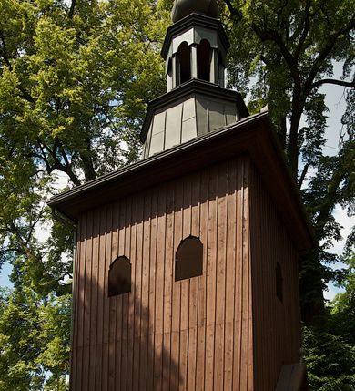 Zdjęcie nr 2: W południowo-wschodniej części placu przy kościele stoi drewniana dzwonnica o konstrukcji słupowej, na kamiennym cokole na planie kwadratu, zwężająca się ku górze. W ścianach wschodniej i zachodniej po dwa, w południowej i północnej po jednym oknie zamkniętym łukiem odcinkowym nadwieszonym. Wejście w ścianie wschodniej, ponad nim daszek dwuspadowy zwieńczony kulą z krzyżem. Dach czterospadowy z ośmiobocznym tamburem z latarnią i hełmem baniastym, zakończony krzyżem. Dach kryty blachą.