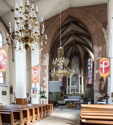 Zdjęcie nr 13: Kościół położony na obszernym placu przylegającym do wschodniej pierzei rynku, na północ od zamku. Plac otoczony ceglanym murem z filarkami. Przed kościołem wydzielony plac, dawny cmentarz, na nim figura św. Jana Kantego. W południowo-wschodnim narożu placu grobowiec księżnej Apolonii Potockiej. Kościół orientowany, halowy, trójnawowy, czteroprzęsłowy, z dwuprzęsłowym zamkniętym wielobocznie prezbiterium. Nawa główna szersza od naw bocznych. Nawy boczne zakończone od wschodu poligonalnymi kaplicami. Od strony północnej do nawy przylega kruchta. W północno-zachodnim narożniku kwadratowa wieża mieszcząca kaplicę w przyziemiu. Do zachodniego przęsła nawy głównej dostawiony głęboki ryzalit z kruchtą w przyziemiu i chórem na piętrze z prospektem organowym. Od północnej strony przylega piętrowa zakrystia, zamknięta wielobocznie. Nawa główna od bocznych oddzielona czworobocznymi filarami o ściętych narożach. Prezbiterium otwarte do korpusu ostrołukową tęczą. W korpusie sklepienie o konstrukcji żelbetowej, stylizowane na gotyckie. W kaplicy pod wieżą sklepienie kolebkowe, w kruchcie zachodniej sufit. Prezbiterium nakryte sklepieniem krzyżowo-żebrowym z żebrami spływającymi na konsole. Wnętrze oświetlają okna ostrołukowe, wypełnione witrażami; dwa w zamknięciu prezbiterium (środkowy otwór zamurowany), dwa na ścianie południowej. Portal z prezbiterium do zakrystii zamknięty łukiem w ośli grzbiet. Otwory drzwiowe prostokątne, różnej wielkości. Kaplica pod wieżą otwarta do wnętrza ostrołukowymi arkadami. Otwory okienne wąskie, prostokątne, ostrołukowe, wypełnione witrażem; cztery w ścianie północnej i południowej, jedno, szersze w ścianie zachodniej nad chórem. Wieża oświetlona małymi, wąskimi oknami zakończonymi łukiem odcinkowym i ostrołukowym. Fasada jednoosiowa, dwukondygnacyjna, zwieńczona szczytem schodkowym z ceglanymi laskami. Niesymetrycznie umieszczone wejście ujęte kamiennym, profilowanym portalem, zamkniętym ostrołukowo. Ponad nim rozglifione ostrołukowe okno. Od północy wieża wbudowana w naroże kościoła, wysunięta nieco przed lico fasady. W dolnej partii kamienna, w górnej ceglana, na rzucie prostokąta, czterokondygnacyjna. Piętro pierwsze i drugie oddzielone kamiennym gzymsem. Trzy dolne kondygnacje gotyckie, czwarta neogotycka (projektu Franciszka Marii Lanciego z 1836 r). Na osi pojedyncze okna. W parterze okno ciosowe, prostokątne, ponad nim wmurowany późnogotycki maswerk ostrołukowy z motywami rybich pęcherzy i psiego zęba, wyżej kartusz z herbem Leliwa. Na pierwszym piętrze okno ostrołukowe z parapetem na konsolkach, w opasce ceglanej zamkniętej ostrołukiem wklęsłym. Drugie piętro, okno ostrołukowe w opasce kamiennej, ponad nim okrągła tarcza zegarowa. Ostatnia kondygnacja ze ściętymi narożami, na których wysunięte przed lico muru krenelażowe wieżyczki zwieńczone kamiennymi szczytami w formie ostrosłupów. Od zachodu masywny łuk półokrągły uformowany z kształtek ceramicznych, w jego polu triforium ostrołukowe. Ponad nim okulus. Pod okapem dachu fryz z ceglanych konsolek oraz gąsiory układane w motyw rybiej łuski. Dach iglicowy. Elewacja południowa. Portal kamienny na cokole, profilowany, ostrołukowy. Archiwolty przechodzące w łuk o formie oślego grzbietu, wsparte na konsolkach zdobionych motywem roślinnym. Skrajna archiwolta z czołgankami zwieńczona pinaklem z kwiatonem. Po bokach analogiczne pinakle; W prezbiterium portal kamienny na cokole, profilowany, ostrołukowy, z dekoracją z motywem skręconego sznura; w kluczu herb Odrowąż, oraz data 1767 i litery LG OH OFP. W ścianę korpusu wmurowane kamienne epitafium ks. Pawła Gabańskiego plebana zatorskiego (zm. 1825), nad nim kartusz z herbem Łodzia.Trzy okna analogiczne jak w fasadzie, i jedno o połowę węższe. Elewacja północna. Kruchta ceglana, na cokole, opięta przyporami. Na osi portal kamienny, profilowany, ostrołukowy. Ponad nim kamienna rozeta z monogramem Marii, po bokach dwa okna o wykroju czworoliścia w okrągłych, kamiennych opaskach. Od strony północno-zachodniej zakrystia na rzucie prostokąta, zamknięta wielobocznie, piętrowa, w dolnej części kamienna (pozostałość pierwotnego kościoła), wyżej ceglana (piętro dobudowane 1915 r.). Od północy portal w opasce ceglanej, zamknięty łukiem odcinkowym. Ponad nim ostrołukowe, ceglane okno. Dwa okna analogiczne jak w fasadzie i jedno o połowę węższe. Kościół opięty przyporami, na wysokości ław okiennych gzyms kapnikowy wyłamany nad portalem północnym. Przypory z kapnikami w zwieńczeniu i na 2/3 wysokości. Pod dachem gzyms konsolkowy. Dach dwuspadowy, sygnaturka wieloboczna z ostrołukowymi prześwitami, zwieńczona hełmem iglicowym.