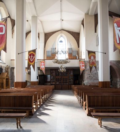 Zdjęcie nr 18: Kościół położony na obszernym placu przylegającym do wschodniej pierzei rynku, na północ od zamku. Plac otoczony ceglanym murem z filarkami. Przed kościołem wydzielony plac, dawny cmentarz, na nim figura św. Jana Kantego. W południowo-wschodnim narożu placu grobowiec księżnej Apolonii Potockiej. Kościół orientowany, halowy, trójnawowy, czteroprzęsłowy, z dwuprzęsłowym zamkniętym wielobocznie prezbiterium. Nawa główna szersza od naw bocznych. Nawy boczne zakończone od wschodu poligonalnymi kaplicami. Od strony północnej do nawy przylega kruchta. W północno-zachodnim narożniku kwadratowa wieża mieszcząca kaplicę w przyziemiu. Do zachodniego przęsła nawy głównej dostawiony głęboki ryzalit z kruchtą w przyziemiu i chórem na piętrze z prospektem organowym. Od północnej strony przylega piętrowa zakrystia, zamknięta wielobocznie. Nawa główna od bocznych oddzielona czworobocznymi filarami o ściętych narożach. Prezbiterium otwarte do korpusu ostrołukową tęczą. W korpusie sklepienie o konstrukcji żelbetowej, stylizowane na gotyckie. W kaplicy pod wieżą sklepienie kolebkowe, w kruchcie zachodniej sufit. Prezbiterium nakryte sklepieniem krzyżowo-żebrowym z żebrami spływającymi na konsole. Wnętrze oświetlają okna ostrołukowe, wypełnione witrażami; dwa w zamknięciu prezbiterium (środkowy otwór zamurowany), dwa na ścianie południowej. Portal z prezbiterium do zakrystii zamknięty łukiem w ośli grzbiet. Otwory drzwiowe prostokątne, różnej wielkości. Kaplica pod wieżą otwarta do wnętrza ostrołukowymi arkadami. Otwory okienne wąskie, prostokątne, ostrołukowe, wypełnione witrażem; cztery w ścianie północnej i południowej, jedno, szersze w ścianie zachodniej nad chórem. Wieża oświetlona małymi, wąskimi oknami zakończonymi łukiem odcinkowym i ostrołukowym. Fasada jednoosiowa, dwukondygnacyjna, zwieńczona szczytem schodkowym z ceglanymi laskami. Niesymetrycznie umieszczone wejście ujęte kamiennym, profilowanym portalem, zamkniętym ostrołukowo. Ponad nim rozglifione ostrołukowe okno. Od północy wieża wbudowana w naroże kościoła, wysunięta nieco przed lico fasady. W dolnej partii kamienna, w górnej ceglana, na rzucie prostokąta, czterokondygnacyjna. Piętro pierwsze i drugie oddzielone kamiennym gzymsem. Trzy dolne kondygnacje gotyckie, czwarta neogotycka (projektu Franciszka Marii Lanciego z 1836 r). Na osi pojedyncze okna. W parterze okno ciosowe, prostokątne, ponad nim wmurowany późnogotycki maswerk ostrołukowy z motywami rybich pęcherzy i psiego zęba, wyżej kartusz z herbem Leliwa. Na pierwszym piętrze okno ostrołukowe z parapetem na konsolkach, w opasce ceglanej zamkniętej ostrołukiem wklęsłym. Drugie piętro, okno ostrołukowe w opasce kamiennej, ponad nim okrągła tarcza zegarowa. Ostatnia kondygnacja ze ściętymi narożami, na których wysunięte przed lico muru krenelażowe wieżyczki zwieńczone kamiennymi szczytami w formie ostrosłupów. Od zachodu masywny łuk półokrągły uformowany z kształtek ceramicznych, w jego polu triforium ostrołukowe. Ponad nim okulus. Pod okapem dachu fryz z ceglanych konsolek oraz gąsiory układane w motyw rybiej łuski. Dach iglicowy. Elewacja południowa. Portal kamienny na cokole, profilowany, ostrołukowy. Archiwolty przechodzące w łuk o formie oślego grzbietu, wsparte na konsolkach zdobionych motywem roślinnym. Skrajna archiwolta z czołgankami zwieńczona pinaklem z kwiatonem. Po bokach analogiczne pinakle; W prezbiterium portal kamienny na cokole, profilowany, ostrołukowy, z dekoracją z motywem skręconego sznura; w kluczu herb Odrowąż, oraz data 1767 i litery LG OH OFP. W ścianę korpusu wmurowane kamienne epitafium ks. Pawła Gabańskiego plebana zatorskiego (zm. 1825), nad nim kartusz z herbem Łodzia.Trzy okna analogiczne jak w fasadzie, i jedno o połowę węższe. Elewacja północna. Kruchta ceglana, na cokole, opięta przyporami. Na osi portal kamienny, profilowany, ostrołukowy. Ponad nim kamienna rozeta z monogramem Marii, po bokach dwa okna o wykroju czworoliścia w okrągłych, kamiennych opaskach. Od strony północno-zachodniej zakrystia na rzucie prostokąta, zamknięta wielobocznie, piętrowa, w dolnej części kamienna (pozostałość pierwotnego kościoła), wyżej ceglana (piętro dobudowane 1915 r.). Od północy portal w opasce ceglanej, zamknięty łukiem odcinkowym. Ponad nim ostrołukowe, ceglane okno. Dwa okna analogiczne jak w fasadzie i jedno o połowę węższe. Kościół opięty przyporami, na wysokości ław okiennych gzyms kapnikowy wyłamany nad portalem północnym. Przypory z kapnikami w zwieńczeniu i na 2/3 wysokości. Pod dachem gzyms konsolkowy. Dach dwuspadowy, sygnaturka wieloboczna z ostrołukowymi prześwitami, zwieńczona hełmem iglicowym.