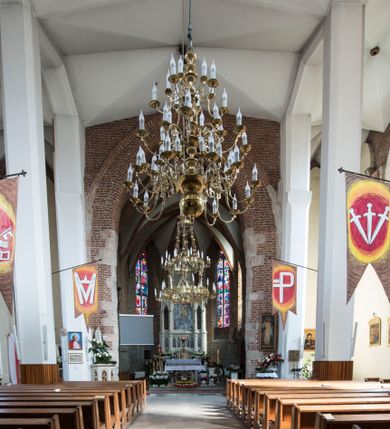 Zdjęcie nr 10: Kościół położony na obszernym placu przylegającym do wschodniej pierzei rynku, na północ od zamku. Plac otoczony ceglanym murem z filarkami. Przed kościołem wydzielony plac, dawny cmentarz, na nim figura św. Jana Kantego. W południowo-wschodnim narożu placu grobowiec księżnej Apolonii Potockiej. Kościół orientowany, halowy, trójnawowy, czteroprzęsłowy, z dwuprzęsłowym zamkniętym wielobocznie prezbiterium. Nawa główna szersza od naw bocznych. Nawy boczne zakończone od wschodu poligonalnymi kaplicami. Od strony północnej do nawy przylega kruchta. W północno-zachodnim narożniku kwadratowa wieża mieszcząca kaplicę w przyziemiu. Do zachodniego przęsła nawy głównej dostawiony głęboki ryzalit z kruchtą w przyziemiu i chórem na piętrze z prospektem organowym. Od północnej strony przylega piętrowa zakrystia, zamknięta wielobocznie. Nawa główna od bocznych oddzielona czworobocznymi filarami o ściętych narożach. Prezbiterium otwarte do korpusu ostrołukową tęczą. W korpusie sklepienie o konstrukcji żelbetowej, stylizowane na gotyckie. W kaplicy pod wieżą sklepienie kolebkowe, w kruchcie zachodniej sufit. Prezbiterium nakryte sklepieniem krzyżowo-żebrowym z żebrami spływającymi na konsole. Wnętrze oświetlają okna ostrołukowe, wypełnione witrażami; dwa w zamknięciu prezbiterium (środkowy otwór zamurowany), dwa na ścianie południowej. Portal z prezbiterium do zakrystii zamknięty łukiem w ośli grzbiet. Otwory drzwiowe prostokątne, różnej wielkości. Kaplica pod wieżą otwarta do wnętrza ostrołukowymi arkadami. Otwory okienne wąskie, prostokątne, ostrołukowe, wypełnione witrażem; cztery w ścianie północnej i południowej, jedno, szersze w ścianie zachodniej nad chórem. Wieża oświetlona małymi, wąskimi oknami zakończonymi łukiem odcinkowym i ostrołukowym. Fasada jednoosiowa, dwukondygnacyjna, zwieńczona szczytem schodkowym z ceglanymi laskami. Niesymetrycznie umieszczone wejście ujęte kamiennym, profilowanym portalem, zamkniętym ostrołukowo. Ponad nim rozglifione ostrołukowe okno. Od północy wieża wbudowana w naroże kościoła, wysunięta nieco przed lico fasady. W dolnej partii kamienna, w górnej ceglana, na rzucie prostokąta, czterokondygnacyjna. Piętro pierwsze i drugie oddzielone kamiennym gzymsem. Trzy dolne kondygnacje gotyckie, czwarta neogotycka (projektu Franciszka Marii Lanciego z 1836 r). Na osi pojedyncze okna. W parterze okno ciosowe, prostokątne, ponad nim wmurowany późnogotycki maswerk ostrołukowy z motywami rybich pęcherzy i psiego zęba, wyżej kartusz z herbem Leliwa. Na pierwszym piętrze okno ostrołukowe z parapetem na konsolkach, w opasce ceglanej zamkniętej ostrołukiem wklęsłym. Drugie piętro, okno ostrołukowe w opasce kamiennej, ponad nim okrągła tarcza zegarowa. Ostatnia kondygnacja ze ściętymi narożami, na których wysunięte przed lico muru krenelażowe wieżyczki zwieńczone kamiennymi szczytami w formie ostrosłupów. Od zachodu masywny łuk półokrągły uformowany z kształtek ceramicznych, w jego polu triforium ostrołukowe. Ponad nim okulus. Pod okapem dachu fryz z ceglanych konsolek oraz gąsiory układane w motyw rybiej łuski. Dach iglicowy. Elewacja południowa. Portal kamienny na cokole, profilowany, ostrołukowy. Archiwolty przechodzące w łuk o formie oślego grzbietu, wsparte na konsolkach zdobionych motywem roślinnym. Skrajna archiwolta z czołgankami zwieńczona pinaklem z kwiatonem. Po bokach analogiczne pinakle; W prezbiterium portal kamienny na cokole, profilowany, ostrołukowy, z dekoracją z motywem skręconego sznura; w kluczu herb Odrowąż, oraz data 1767 i litery LG OH OFP. W ścianę korpusu wmurowane kamienne epitafium ks. Pawła Gabańskiego plebana zatorskiego (zm. 1825), nad nim kartusz z herbem Łodzia.Trzy okna analogiczne jak w fasadzie, i jedno o połowę węższe. Elewacja północna. Kruchta ceglana, na cokole, opięta przyporami. Na osi portal kamienny, profilowany, ostrołukowy. Ponad nim kamienna rozeta z monogramem Marii, po bokach dwa okna o wykroju czworoliścia w okrągłych, kamiennych opaskach. Od strony północno-zachodniej zakrystia na rzucie prostokąta, zamknięta wielobocznie, piętrowa, w dolnej części kamienna (pozostałość pierwotnego kościoła), wyżej ceglana (piętro dobudowane 1915 r.). Od północy portal w opasce ceglanej, zamknięty łukiem odcinkowym. Ponad nim ostrołukowe, ceglane okno. Dwa okna analogiczne jak w fasadzie i jedno o połowę węższe. Kościół opięty przyporami, na wysokości ław okiennych gzyms kapnikowy wyłamany nad portalem północnym. Przypory z kapnikami w zwieńczeniu i na 2/3 wysokości. Pod dachem gzyms konsolkowy. Dach dwuspadowy, sygnaturka wieloboczna z ostrołukowymi prześwitami, zwieńczona hełmem iglicowym.