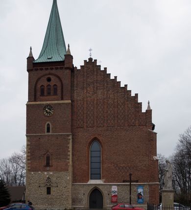 Zdjęcie nr 3: Kościół położony na obszernym placu przylegającym do wschodniej pierzei rynku, na północ od zamku. Plac otoczony ceglanym murem z filarkami. Przed kościołem wydzielony plac, dawny cmentarz, na nim figura św. Jana Kantego. W południowo-wschodnim narożu placu grobowiec księżnej Apolonii Potockiej. Kościół orientowany, halowy, trójnawowy, czteroprzęsłowy, z dwuprzęsłowym zamkniętym wielobocznie prezbiterium. Nawa główna szersza od naw bocznych. Nawy boczne zakończone od wschodu poligonalnymi kaplicami. Od strony północnej do nawy przylega kruchta. W północno-zachodnim narożniku kwadratowa wieża mieszcząca kaplicę w przyziemiu. Do zachodniego przęsła nawy głównej dostawiony głęboki ryzalit z kruchtą w przyziemiu i chórem na piętrze z prospektem organowym. Od północnej strony przylega piętrowa zakrystia, zamknięta wielobocznie. Nawa główna od bocznych oddzielona czworobocznymi filarami o ściętych narożach. Prezbiterium otwarte do korpusu ostrołukową tęczą. W korpusie sklepienie o konstrukcji żelbetowej, stylizowane na gotyckie. W kaplicy pod wieżą sklepienie kolebkowe, w kruchcie zachodniej sufit. Prezbiterium nakryte sklepieniem krzyżowo-żebrowym z żebrami spływającymi na konsole. Wnętrze oświetlają okna ostrołukowe, wypełnione witrażami; dwa w zamknięciu prezbiterium (środkowy otwór zamurowany), dwa na ścianie południowej. Portal z prezbiterium do zakrystii zamknięty łukiem w ośli grzbiet. Otwory drzwiowe prostokątne, różnej wielkości. Kaplica pod wieżą otwarta do wnętrza ostrołukowymi arkadami. Otwory okienne wąskie, prostokątne, ostrołukowe, wypełnione witrażem; cztery w ścianie północnej i południowej, jedno, szersze w ścianie zachodniej nad chórem. Wieża oświetlona małymi, wąskimi oknami zakończonymi łukiem odcinkowym i ostrołukowym. Fasada jednoosiowa, dwukondygnacyjna, zwieńczona szczytem schodkowym z ceglanymi laskami. Niesymetrycznie umieszczone wejście ujęte kamiennym, profilowanym portalem, zamkniętym ostrołukowo. Ponad nim rozglifione ostrołukowe okno. Od północy wieża wbudowana w naroże kościoła, wysunięta nieco przed lico fasady. W dolnej partii kamienna, w górnej ceglana, na rzucie prostokąta, czterokondygnacyjna. Piętro pierwsze i drugie oddzielone kamiennym gzymsem. Trzy dolne kondygnacje gotyckie, czwarta neogotycka (projektu Franciszka Marii Lanciego z 1836 r). Na osi pojedyncze okna. W parterze okno ciosowe, prostokątne, ponad nim wmurowany późnogotycki maswerk ostrołukowy z motywami rybich pęcherzy i psiego zęba, wyżej kartusz z herbem Leliwa. Na pierwszym piętrze okno ostrołukowe z parapetem na konsolkach, w opasce ceglanej zamkniętej ostrołukiem wklęsłym. Drugie piętro, okno ostrołukowe w opasce kamiennej, ponad nim okrągła tarcza zegarowa. Ostatnia kondygnacja ze ściętymi narożami, na których wysunięte przed lico muru krenelażowe wieżyczki zwieńczone kamiennymi szczytami w formie ostrosłupów. Od zachodu masywny łuk półokrągły uformowany z kształtek ceramicznych, w jego polu triforium ostrołukowe. Ponad nim okulus. Pod okapem dachu fryz z ceglanych konsolek oraz gąsiory układane w motyw rybiej łuski. Dach iglicowy. Elewacja południowa. Portal kamienny na cokole, profilowany, ostrołukowy. Archiwolty przechodzące w łuk o formie oślego grzbietu, wsparte na konsolkach zdobionych motywem roślinnym. Skrajna archiwolta z czołgankami zwieńczona pinaklem z kwiatonem. Po bokach analogiczne pinakle; W prezbiterium portal kamienny na cokole, profilowany, ostrołukowy, z dekoracją z motywem skręconego sznura; w kluczu herb Odrowąż, oraz data 1767 i litery LG OH OFP. W ścianę korpusu wmurowane kamienne epitafium ks. Pawła Gabańskiego plebana zatorskiego (zm. 1825), nad nim kartusz z herbem Łodzia.Trzy okna analogiczne jak w fasadzie, i jedno o połowę węższe. Elewacja północna. Kruchta ceglana, na cokole, opięta przyporami. Na osi portal kamienny, profilowany, ostrołukowy. Ponad nim kamienna rozeta z monogramem Marii, po bokach dwa okna o wykroju czworoliścia w okrągłych, kamiennych opaskach. Od strony północno-zachodniej zakrystia na rzucie prostokąta, zamknięta wielobocznie, piętrowa, w dolnej części kamienna (pozostałość pierwotnego kościoła), wyżej ceglana (piętro dobudowane 1915 r.). Od północy portal w opasce ceglanej, zamknięty łukiem odcinkowym. Ponad nim ostrołukowe, ceglane okno. Dwa okna analogiczne jak w fasadzie i jedno o połowę węższe. Kościół opięty przyporami, na wysokości ław okiennych gzyms kapnikowy wyłamany nad portalem północnym. Przypory z kapnikami w zwieńczeniu i na 2/3 wysokości. Pod dachem gzyms konsolkowy. Dach dwuspadowy, sygnaturka wieloboczna z ostrołukowymi prześwitami, zwieńczona hełmem iglicowym.
