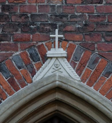 Zdjęcie nr 21: Kościół położony na obszernym placu przylegającym do wschodniej pierzei rynku, na północ od zamku. Plac otoczony ceglanym murem z filarkami. Przed kościołem wydzielony plac, dawny cmentarz, na nim figura św. Jana Kantego. W południowo-wschodnim narożu placu grobowiec księżnej Apolonii Potockiej. Kościół orientowany, halowy, trójnawowy, czteroprzęsłowy, z dwuprzęsłowym zamkniętym wielobocznie prezbiterium. Nawa główna szersza od naw bocznych. Nawy boczne zakończone od wschodu poligonalnymi kaplicami. Od strony północnej do nawy przylega kruchta. W północno-zachodnim narożniku kwadratowa wieża mieszcząca kaplicę w przyziemiu. Do zachodniego przęsła nawy głównej dostawiony głęboki ryzalit z kruchtą w przyziemiu i chórem na piętrze z prospektem organowym. Od północnej strony przylega piętrowa zakrystia, zamknięta wielobocznie. Nawa główna od bocznych oddzielona czworobocznymi filarami o ściętych narożach. Prezbiterium otwarte do korpusu ostrołukową tęczą. W korpusie sklepienie o konstrukcji żelbetowej, stylizowane na gotyckie. W kaplicy pod wieżą sklepienie kolebkowe, w kruchcie zachodniej sufit. Prezbiterium nakryte sklepieniem krzyżowo-żebrowym z żebrami spływającymi na konsole. Wnętrze oświetlają okna ostrołukowe, wypełnione witrażami; dwa w zamknięciu prezbiterium (środkowy otwór zamurowany), dwa na ścianie południowej. Portal z prezbiterium do zakrystii zamknięty łukiem w ośli grzbiet. Otwory drzwiowe prostokątne, różnej wielkości. Kaplica pod wieżą otwarta do wnętrza ostrołukowymi arkadami. Otwory okienne wąskie, prostokątne, ostrołukowe, wypełnione witrażem; cztery w ścianie północnej i południowej, jedno, szersze w ścianie zachodniej nad chórem. Wieża oświetlona małymi, wąskimi oknami zakończonymi łukiem odcinkowym i ostrołukowym. Fasada jednoosiowa, dwukondygnacyjna, zwieńczona szczytem schodkowym z ceglanymi laskami. Niesymetrycznie umieszczone wejście ujęte kamiennym, profilowanym portalem, zamkniętym ostrołukowo. Ponad nim rozglifione ostrołukowe okno. Od północy wieża wbudowana w naroże kościoła, wysunięta nieco przed lico fasady. W dolnej partii kamienna, w górnej ceglana, na rzucie prostokąta, czterokondygnacyjna. Piętro pierwsze i drugie oddzielone kamiennym gzymsem. Trzy dolne kondygnacje gotyckie, czwarta neogotycka (projektu Franciszka Marii Lanciego z 1836 r). Na osi pojedyncze okna. W parterze okno ciosowe, prostokątne, ponad nim wmurowany późnogotycki maswerk ostrołukowy z motywami rybich pęcherzy i psiego zęba, wyżej kartusz z herbem Leliwa. Na pierwszym piętrze okno ostrołukowe z parapetem na konsolkach, w opasce ceglanej zamkniętej ostrołukiem wklęsłym. Drugie piętro, okno ostrołukowe w opasce kamiennej, ponad nim okrągła tarcza zegarowa. Ostatnia kondygnacja ze ściętymi narożami, na których wysunięte przed lico muru krenelażowe wieżyczki zwieńczone kamiennymi szczytami w formie ostrosłupów. Od zachodu masywny łuk półokrągły uformowany z kształtek ceramicznych, w jego polu triforium ostrołukowe. Ponad nim okulus. Pod okapem dachu fryz z ceglanych konsolek oraz gąsiory układane w motyw rybiej łuski. Dach iglicowy. Elewacja południowa. Portal kamienny na cokole, profilowany, ostrołukowy. Archiwolty przechodzące w łuk o formie oślego grzbietu, wsparte na konsolkach zdobionych motywem roślinnym. Skrajna archiwolta z czołgankami zwieńczona pinaklem z kwiatonem. Po bokach analogiczne pinakle; W prezbiterium portal kamienny na cokole, profilowany, ostrołukowy, z dekoracją z motywem skręconego sznura; w kluczu herb Odrowąż, oraz data 1767 i litery LG OH OFP. W ścianę korpusu wmurowane kamienne epitafium ks. Pawła Gabańskiego plebana zatorskiego (zm. 1825), nad nim kartusz z herbem Łodzia.Trzy okna analogiczne jak w fasadzie, i jedno o połowę węższe. Elewacja północna. Kruchta ceglana, na cokole, opięta przyporami. Na osi portal kamienny, profilowany, ostrołukowy. Ponad nim kamienna rozeta z monogramem Marii, po bokach dwa okna o wykroju czworoliścia w okrągłych, kamiennych opaskach. Od strony północno-zachodniej zakrystia na rzucie prostokąta, zamknięta wielobocznie, piętrowa, w dolnej części kamienna (pozostałość pierwotnego kościoła), wyżej ceglana (piętro dobudowane 1915 r.). Od północy portal w opasce ceglanej, zamknięty łukiem odcinkowym. Ponad nim ostrołukowe, ceglane okno. Dwa okna analogiczne jak w fasadzie i jedno o połowę węższe. Kościół opięty przyporami, na wysokości ław okiennych gzyms kapnikowy wyłamany nad portalem północnym. Przypory z kapnikami w zwieńczeniu i na 2/3 wysokości. Pod dachem gzyms konsolkowy. Dach dwuspadowy, sygnaturka wieloboczna z ostrołukowymi prześwitami, zwieńczona hełmem iglicowym.