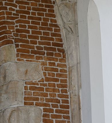 Zdjęcie nr 38: Kościół położony na obszernym placu przylegającym do wschodniej pierzei rynku, na północ od zamku. Plac otoczony ceglanym murem z filarkami. Przed kościołem wydzielony plac, dawny cmentarz, na nim figura św. Jana Kantego. W południowo-wschodnim narożu placu grobowiec księżnej Apolonii Potockiej. Kościół orientowany, halowy, trójnawowy, czteroprzęsłowy, z dwuprzęsłowym zamkniętym wielobocznie prezbiterium. Nawa główna szersza od naw bocznych. Nawy boczne zakończone od wschodu poligonalnymi kaplicami. Od strony północnej do nawy przylega kruchta. W północno-zachodnim narożniku kwadratowa wieża mieszcząca kaplicę w przyziemiu. Do zachodniego przęsła nawy głównej dostawiony głęboki ryzalit z kruchtą w przyziemiu i chórem na piętrze z prospektem organowym. Od północnej strony przylega piętrowa zakrystia, zamknięta wielobocznie. Nawa główna od bocznych oddzielona czworobocznymi filarami o ściętych narożach. Prezbiterium otwarte do korpusu ostrołukową tęczą. W korpusie sklepienie o konstrukcji żelbetowej, stylizowane na gotyckie. W kaplicy pod wieżą sklepienie kolebkowe, w kruchcie zachodniej sufit. Prezbiterium nakryte sklepieniem krzyżowo-żebrowym z żebrami spływającymi na konsole. Wnętrze oświetlają okna ostrołukowe, wypełnione witrażami; dwa w zamknięciu prezbiterium (środkowy otwór zamurowany), dwa na ścianie południowej. Portal z prezbiterium do zakrystii zamknięty łukiem w ośli grzbiet. Otwory drzwiowe prostokątne, różnej wielkości. Kaplica pod wieżą otwarta do wnętrza ostrołukowymi arkadami. Otwory okienne wąskie, prostokątne, ostrołukowe, wypełnione witrażem; cztery w ścianie północnej i południowej, jedno, szersze w ścianie zachodniej nad chórem. Wieża oświetlona małymi, wąskimi oknami zakończonymi łukiem odcinkowym i ostrołukowym. Fasada jednoosiowa, dwukondygnacyjna, zwieńczona szczytem schodkowym z ceglanymi laskami. Niesymetrycznie umieszczone wejście ujęte kamiennym, profilowanym portalem, zamkniętym ostrołukowo. Ponad nim rozglifione ostrołukowe okno. Od północy wieża wbudowana w naroże kościoła, wysunięta nieco przed lico fasady. W dolnej partii kamienna, w górnej ceglana, na rzucie prostokąta, czterokondygnacyjna. Piętro pierwsze i drugie oddzielone kamiennym gzymsem. Trzy dolne kondygnacje gotyckie, czwarta neogotycka (projektu Franciszka Marii Lanciego z 1836 r). Na osi pojedyncze okna. W parterze okno ciosowe, prostokątne, ponad nim wmurowany późnogotycki maswerk ostrołukowy z motywami rybich pęcherzy i psiego zęba, wyżej kartusz z herbem Leliwa. Na pierwszym piętrze okno ostrołukowe z parapetem na konsolkach, w opasce ceglanej zamkniętej ostrołukiem wklęsłym. Drugie piętro, okno ostrołukowe w opasce kamiennej, ponad nim okrągła tarcza zegarowa. Ostatnia kondygnacja ze ściętymi narożami, na których wysunięte przed lico muru krenelażowe wieżyczki zwieńczone kamiennymi szczytami w formie ostrosłupów. Od zachodu masywny łuk półokrągły uformowany z kształtek ceramicznych, w jego polu triforium ostrołukowe. Ponad nim okulus. Pod okapem dachu fryz z ceglanych konsolek oraz gąsiory układane w motyw rybiej łuski. Dach iglicowy. Elewacja południowa. Portal kamienny na cokole, profilowany, ostrołukowy. Archiwolty przechodzące w łuk o formie oślego grzbietu, wsparte na konsolkach zdobionych motywem roślinnym. Skrajna archiwolta z czołgankami zwieńczona pinaklem z kwiatonem. Po bokach analogiczne pinakle; W prezbiterium portal kamienny na cokole, profilowany, ostrołukowy, z dekoracją z motywem skręconego sznura; w kluczu herb Odrowąż, oraz data 1767 i litery LG OH OFP. W ścianę korpusu wmurowane kamienne epitafium ks. Pawła Gabańskiego plebana zatorskiego (zm. 1825), nad nim kartusz z herbem Łodzia.Trzy okna analogiczne jak w fasadzie, i jedno o połowę węższe. Elewacja północna. Kruchta ceglana, na cokole, opięta przyporami. Na osi portal kamienny, profilowany, ostrołukowy. Ponad nim kamienna rozeta z monogramem Marii, po bokach dwa okna o wykroju czworoliścia w okrągłych, kamiennych opaskach. Od strony północno-zachodniej zakrystia na rzucie prostokąta, zamknięta wielobocznie, piętrowa, w dolnej części kamienna (pozostałość pierwotnego kościoła), wyżej ceglana (piętro dobudowane 1915 r.). Od północy portal w opasce ceglanej, zamknięty łukiem odcinkowym. Ponad nim ostrołukowe, ceglane okno. Dwa okna analogiczne jak w fasadzie i jedno o połowę węższe. Kościół opięty przyporami, na wysokości ław okiennych gzyms kapnikowy wyłamany nad portalem północnym. Przypory z kapnikami w zwieńczeniu i na 2/3 wysokości. Pod dachem gzyms konsolkowy. Dach dwuspadowy, sygnaturka wieloboczna z ostrołukowymi prześwitami, zwieńczona hełmem iglicowym.