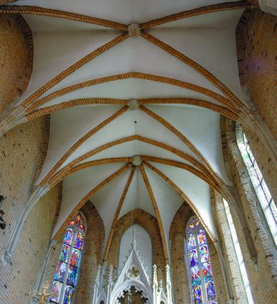 Zdjęcie nr 52: Kościół położony na obszernym placu przylegającym do wschodniej pierzei rynku, na północ od zamku. Plac otoczony ceglanym murem z filarkami. Przed kościołem wydzielony plac, dawny cmentarz, na nim figura św. Jana Kantego. W południowo-wschodnim narożu placu grobowiec księżnej Apolonii Potockiej. Kościół orientowany, halowy, trójnawowy, czteroprzęsłowy, z dwuprzęsłowym zamkniętym wielobocznie prezbiterium. Nawa główna szersza od naw bocznych. Nawy boczne zakończone od wschodu poligonalnymi kaplicami. Od strony północnej do nawy przylega kruchta. W północno-zachodnim narożniku kwadratowa wieża mieszcząca kaplicę w przyziemiu. Do zachodniego przęsła nawy głównej dostawiony głęboki ryzalit z kruchtą w przyziemiu i chórem na piętrze z prospektem organowym. Od północnej strony przylega piętrowa zakrystia, zamknięta wielobocznie. Nawa główna od bocznych oddzielona czworobocznymi filarami o ściętych narożach. Prezbiterium otwarte do korpusu ostrołukową tęczą. W korpusie sklepienie o konstrukcji żelbetowej, stylizowane na gotyckie. W kaplicy pod wieżą sklepienie kolebkowe, w kruchcie zachodniej sufit. Prezbiterium nakryte sklepieniem krzyżowo-żebrowym z żebrami spływającymi na konsole. Wnętrze oświetlają okna ostrołukowe, wypełnione witrażami; dwa w zamknięciu prezbiterium (środkowy otwór zamurowany), dwa na ścianie południowej. Portal z prezbiterium do zakrystii zamknięty łukiem w ośli grzbiet. Otwory drzwiowe prostokątne, różnej wielkości. Kaplica pod wieżą otwarta do wnętrza ostrołukowymi arkadami. Otwory okienne wąskie, prostokątne, ostrołukowe, wypełnione witrażem; cztery w ścianie północnej i południowej, jedno, szersze w ścianie zachodniej nad chórem. Wieża oświetlona małymi, wąskimi oknami zakończonymi łukiem odcinkowym i ostrołukowym. Fasada jednoosiowa, dwukondygnacyjna, zwieńczona szczytem schodkowym z ceglanymi laskami. Niesymetrycznie umieszczone wejście ujęte kamiennym, profilowanym portalem, zamkniętym ostrołukowo. Ponad nim rozglifione ostrołukowe okno. Od północy wieża wbudowana w naroże kościoła, wysunięta nieco przed lico fasady. W dolnej partii kamienna, w górnej ceglana, na rzucie prostokąta, czterokondygnacyjna. Piętro pierwsze i drugie oddzielone kamiennym gzymsem. Trzy dolne kondygnacje gotyckie, czwarta neogotycka (projektu Franciszka Marii Lanciego z 1836 r). Na osi pojedyncze okna. W parterze okno ciosowe, prostokątne, ponad nim wmurowany późnogotycki maswerk ostrołukowy z motywami rybich pęcherzy i psiego zęba, wyżej kartusz z herbem Leliwa. Na pierwszym piętrze okno ostrołukowe z parapetem na konsolkach, w opasce ceglanej zamkniętej ostrołukiem wklęsłym. Drugie piętro, okno ostrołukowe w opasce kamiennej, ponad nim okrągła tarcza zegarowa. Ostatnia kondygnacja ze ściętymi narożami, na których wysunięte przed lico muru krenelażowe wieżyczki zwieńczone kamiennymi szczytami w formie ostrosłupów. Od zachodu masywny łuk półokrągły uformowany z kształtek ceramicznych, w jego polu triforium ostrołukowe. Ponad nim okulus. Pod okapem dachu fryz z ceglanych konsolek oraz gąsiory układane w motyw rybiej łuski. Dach iglicowy. Elewacja południowa. Portal kamienny na cokole, profilowany, ostrołukowy. Archiwolty przechodzące w łuk o formie oślego grzbietu, wsparte na konsolkach zdobionych motywem roślinnym. Skrajna archiwolta z czołgankami zwieńczona pinaklem z kwiatonem. Po bokach analogiczne pinakle; W prezbiterium portal kamienny na cokole, profilowany, ostrołukowy, z dekoracją z motywem skręconego sznura; w kluczu herb Odrowąż, oraz data 1767 i litery LG OH OFP. W ścianę korpusu wmurowane kamienne epitafium ks. Pawła Gabańskiego plebana zatorskiego (zm. 1825), nad nim kartusz z herbem Łodzia.Trzy okna analogiczne jak w fasadzie, i jedno o połowę węższe. Elewacja północna. Kruchta ceglana, na cokole, opięta przyporami. Na osi portal kamienny, profilowany, ostrołukowy. Ponad nim kamienna rozeta z monogramem Marii, po bokach dwa okna o wykroju czworoliścia w okrągłych, kamiennych opaskach. Od strony północno-zachodniej zakrystia na rzucie prostokąta, zamknięta wielobocznie, piętrowa, w dolnej części kamienna (pozostałość pierwotnego kościoła), wyżej ceglana (piętro dobudowane 1915 r.). Od północy portal w opasce ceglanej, zamknięty łukiem odcinkowym. Ponad nim ostrołukowe, ceglane okno. Dwa okna analogiczne jak w fasadzie i jedno o połowę węższe. Kościół opięty przyporami, na wysokości ław okiennych gzyms kapnikowy wyłamany nad portalem północnym. Przypory z kapnikami w zwieńczeniu i na 2/3 wysokości. Pod dachem gzyms konsolkowy. Dach dwuspadowy, sygnaturka wieloboczna z ostrołukowymi prześwitami, zwieńczona hełmem iglicowym.