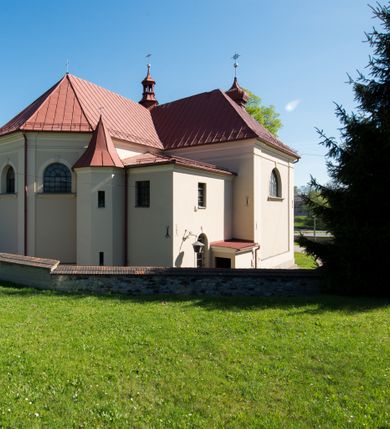 Zdjęcie nr 15: Kościół murowany, jednonawowy, z wieżą częściowo wtopioną w elewację zachodnią składający się z nawy, transeptu, zakrystii od północy z mieszczącym się na piętrze skarbcem i przystawionej od wschodu wieżyczki klatki schodowej oraz kruchty od południa. Prezbiterium dwuprzęsłowe, zamknięte trójbocznie. Nawa główna podzielona masywnymi opilastrowanymi filarami. Sklepienie prezbiterium i nawy kolebkowe z lunetami, skrzyżowania z transeptem. Od południa chór muzyczny mieszczący się między pierwszymi filarami i powyżej kruchty wejściowej. W prezbiterium okna w każdym przęśle, po każdej stronie nawy po dwa, w transepcie po trzy, w kruchcie dwa. Główne wejście od zachodu, kolejne do zakrystii i od południa. Ściany i sklepienia kościoła pokrywa polichromia złożona z geometryzujących dekoracji floralnych. 
Wschodnią elewację frontową kościoła tworzy trójosiowa, wieżowa fasada. Oś kompozycji stanowi wysunięta ryzalitowo dwukondygnacyjna wieża ze ściętymi narożami, które zaakcentowane są poprzez pilastry. Ściana czołowa wieży wypełniona w pierwszej kondygnacji wklęsłą płyciną, z portalem o wykroju prostokątnym, z odcinkiem gzymsu w zwieńczeniu. Ponad nim prostokątne okno zakończone łukiem pełnym. Kondygnacje rozdzielone za pomocą masywnego gzymsu. Druga kondygnacja wieży wypełniona analogicznie prostokątną płyciną, w którą wkomponowany jest wypukły panel w kształcie leżącego prostokąta. Nad nim okno o obramieniu i wykroju identycznym jak w kondygnacji niższej. Całość zwieńczona za pomocą gzymsu podokapowego i baniastego hełmu wieżowego o ściętych narożach, na które nałożona jest kopułka w formie cebulastej. Osie boczne cofnięte w stosunku do wysuniętej wieży i zrytmizowane podziałem ramowym. Tak jak w osi głównej pierwsza kondygnacja wypełniona jest wklęsłą płyciną w formie wydłużonego, stojącego prostokąta. Nad gzymsem trójkątny spływ przysłonięty wieżą. Elewacje boczne i tylna ukształtowane jednorodnie. Zrytmizowane podziałem ramowym i przeprute oknami umieszczonymi w prostokątnych płycinach. Ramiona transeptu oraz prezbiterium zrytmizowane są za pomocą pilastrów załamanych na narożach. Od południa do korpusu przylega niska kruchta. Prowadzi do niej wejście o wykroju prostokątnym z profilowanym w tynku portalem i z odcinkiem gzymsu w zwieńczeniu. Od północy pomiędzy prezbiterium, a ramieniem transeptu wprowadzona została piętrowa przybudówka zakrystii. W elewacji tej partii kościoła brak jest znaczących podziałów. Okna i drzwi tam się znajdujące mają formę stojącego prostokąta i pozbawione są jakichkolwiek obramień. Kościół pokryty dwuspadowym, jednokalenicowym dachem, nad zakrystią i kruchtami umieszczono daszki dwuspadowe. Wieża nakryta jest hełmem cebulastym. Całość pokryta została malowaną blachą.
