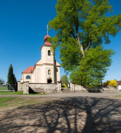 Zdjęcie nr 4: Kościół murowany, jednonawowy, z wieżą częściowo wtopioną w elewację zachodnią składający się z nawy, transeptu, zakrystii od północy z mieszczącym się na piętrze skarbcem i przystawionej od wschodu wieżyczki klatki schodowej oraz kruchty od południa. Prezbiterium dwuprzęsłowe, zamknięte trójbocznie. Nawa główna podzielona masywnymi opilastrowanymi filarami. Sklepienie prezbiterium i nawy kolebkowe z lunetami, skrzyżowania z transeptem. Od południa chór muzyczny mieszczący się między pierwszymi filarami i powyżej kruchty wejściowej. W prezbiterium okna w każdym przęśle, po każdej stronie nawy po dwa, w transepcie po trzy, w kruchcie dwa. Główne wejście od zachodu, kolejne do zakrystii i od południa. Ściany i sklepienia kościoła pokrywa polichromia złożona z geometryzujących dekoracji floralnych. 
Wschodnią elewację frontową kościoła tworzy trójosiowa, wieżowa fasada. Oś kompozycji stanowi wysunięta ryzalitowo dwukondygnacyjna wieża ze ściętymi narożami, które zaakcentowane są poprzez pilastry. Ściana czołowa wieży wypełniona w pierwszej kondygnacji wklęsłą płyciną, z portalem o wykroju prostokątnym, z odcinkiem gzymsu w zwieńczeniu. Ponad nim prostokątne okno zakończone łukiem pełnym. Kondygnacje rozdzielone za pomocą masywnego gzymsu. Druga kondygnacja wieży wypełniona analogicznie prostokątną płyciną, w którą wkomponowany jest wypukły panel w kształcie leżącego prostokąta. Nad nim okno o obramieniu i wykroju identycznym jak w kondygnacji niższej. Całość zwieńczona za pomocą gzymsu podokapowego i baniastego hełmu wieżowego o ściętych narożach, na które nałożona jest kopułka w formie cebulastej. Osie boczne cofnięte w stosunku do wysuniętej wieży i zrytmizowane podziałem ramowym. Tak jak w osi głównej pierwsza kondygnacja wypełniona jest wklęsłą płyciną w formie wydłużonego, stojącego prostokąta. Nad gzymsem trójkątny spływ przysłonięty wieżą. Elewacje boczne i tylna ukształtowane jednorodnie. Zrytmizowane podziałem ramowym i przeprute oknami umieszczonymi w prostokątnych płycinach. Ramiona transeptu oraz prezbiterium zrytmizowane są za pomocą pilastrów załamanych na narożach. Od południa do korpusu przylega niska kruchta. Prowadzi do niej wejście o wykroju prostokątnym z profilowanym w tynku portalem i z odcinkiem gzymsu w zwieńczeniu. Od północy pomiędzy prezbiterium, a ramieniem transeptu wprowadzona została piętrowa przybudówka zakrystii. W elewacji tej partii kościoła brak jest znaczących podziałów. Okna i drzwi tam się znajdujące mają formę stojącego prostokąta i pozbawione są jakichkolwiek obramień. Kościół pokryty dwuspadowym, jednokalenicowym dachem, nad zakrystią i kruchtami umieszczono daszki dwuspadowe. Wieża nakryta jest hełmem cebulastym. Całość pokryta została malowaną blachą.
