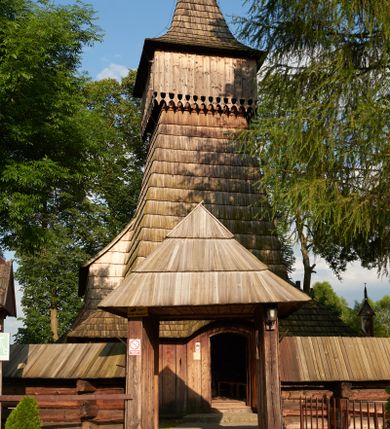 Zdjęcie nr 1: Orientowany, jednoprzestrzenny, nawa na rzucie prostokąta, z węższym, prostokątnym prezbiterium, przy którym od północy wąska zakrystia. Od zachodu przy nawie wieża na rzucie kwadratu, od południa kruchta. Wnętrze nakryte stropem, w nawie z zaskrzynieniem. Portale zachodni i do zakrystii ostrołukowe, fazowane; portal południowy zamknięty łukiem kotarowym. Okna prostokątne, w prezbiterium od południa okno bliźnie, od wschodu zamknięte łukiem kotarowym.  Wokół podcienia, obecnie zaszalowane. Więźba dachowa jętkowa, ze znakami montażowymi.  Dach nad nawą i prezbiterium jednokalenicowy, dwuspadowy, nad nawą z połaciami przedłużonymi na zaskrzynienia i od północy nad zakrystię. Na kalenicy wieżyczka na sygnaturkę z baniastym hełmem.  Wieża o ścianach pochyłych, z nadwieszoną izbicą, zwieńczona ostrosłupowym hełmem. Wokół kościoła ogrodzenie belek układanych na zrąb, z dwiema bramkami. 