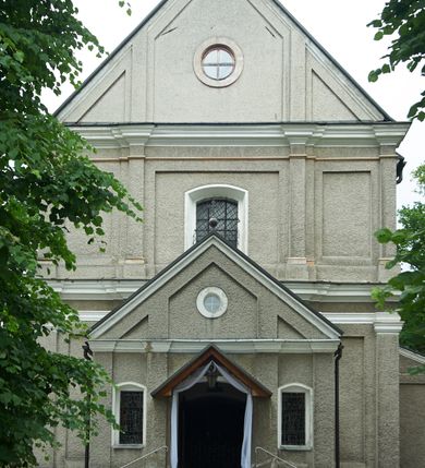 Zdjęcie nr 2: Kościół murowany, orientowany, jednonawowy (z dodatkową przestrzenią od południa powstałą w wyniku połączenia trzech kaplic), z półkoliście zamkniętym prezbiterium, z prostokątną zakrystią od północy, z kruchtą na osi nawy głównej oraz drugą od północy; między zakrystią a kruchtą północną babiniec. 
Nawa szersza od prezbiterium, prostokątna, trójprzęsłowa, ze sklepieniem kolebkowym z lunetami na gurtach. Od zachodu chór muzyczny wsparty na kolumnach. Ściany nawy podzielone zdwojonymi pilastrami, między którymi nisze arkadowe, od południa półokrągłe arkady łączące nawę główną z nawą boczną. Partię ścian od sklepienia oddziela pełne belkowanie wyłamane na osi pilastrów, które jest kontynuowane w przekrytym sklepieniem kolebkowym z lunetami prezbiterium.  
W partii przyziemia oraz sklepienia prostokątne okna w rozglifionych obramieniach zamkniętych łukiem odcinkowym, na osi prezbiterium owalne. Od zachodu oraz od południa drzwi zamknięte łukiem odcinkowym. 
Fasada trójosiowa, dwukondygnacyjna, zwieńczona trójkątnym przyczółkiem, poprzedzona jednokondygnacyjną kruchtą, do której wchodzi się po sześciostopniowych schodach. Osie rozdzielone są pojedynczymi lub zdwojonymi pilastrami, kondygnacje dzieli bogato profilowane belkowanie. W kruchcie drzwi o wykroju prostokąta zamknięte łukiem odcinkowym, okna w osiach bocznych o identycznym jak drzwi wykroju; okulus w szczycie. W osi środkowej drugiej kondygnacji fasady okno prostokątne, zamknięte łukiem odcinkowym, a u szczytu okulus. 
Na elewacjach kontynuowany jest gzyms oddzielający drugą kondygnację i partię dachu, pionowe podziały utworzone zostały przez lizeny. 
Nawa główna oraz kruchty nakryte dachami dwuspadowymi, część nawy bocznej, zakrystia oraz babiniec jednospadowymi, druga część nawy bocznej trójspadowym, zakrystia dwuspadowym zamkniętym półkoliście. Dwie wieżyczki na sygnaturki: jedna nad nawą główną, druga, mniejsza nad prezbiterium. Obie przeprute arkadami, zwieńczone kopułami z kulą i krzyżem. 
Do najważniejszych elementów wyposażenia należą: ołtarz główny późnobarokowy z obrazem Przemienienia Pańskiego przywieziony z Rzymu w 1723 roku, dwa regencyjne ołtarze boczne z barokowymi obrazami Matki Boskiej z Dzieciątkiem oraz św. Katarzyny, oba ozdobione sukienkami oraz obraz z przedstawieniem św. Józefa, pochodzący z trzeciego ołtarza wisi teraz na ścianie nawy głównej. 
