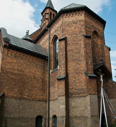 Zdjęcie nr 3: Murowana z cegły, orientowana, trzynawowa bazylika emporowa z prezbiterium zamkniętym trójbocznie. Do jednej czwartej wysokości murów lico kamienne, całość obiega cokół. Fasada dwukondygnacyjna, trójosiowa; oś środkowa wysunięta przed lico muru. Podziały pionowe tworzą dwuuskokowe przypory, poziome gzyms w połowie wysokości osi środkowej. Na osi portal ostrołukowy, uskokowy, flankowany filarami wspartymi na wysokich cokołach. W filarach fragmenty laski. Powyżej wsporniki podtrzymujące wąską archiwoltę otoczoną fryzem arkadowym. Nad otworem drzwiowym tympanon o zarysie łuku ostrego. W zwieńczeniu trójkątny przyczółek, którego ramiona spływają na konsolki oparte na filarach; całość wieńczy krzyż. Ponad portalem dwa okna w uskokowym obramieniu zakończonym łukiem ostrym. Ponad nimi okrągłe okno, wyżej kamienny kartusz z herbem fundatorki. Fasadę wieńczy ząbkowanie i fryz arkadowy. W skrajnych osiach okna ostrołukowe. W dolnym, lewym rogu osi środkowej data: MCMV. Podziały ścian nawy bocznej stanowią trójskokowe przypory; pomiędzy nimi okna ostrołukowe w uskokowych obramieniach. Ponad oknami ząbkowanie, profilowany architraw, fryz i gzyms wsparty na kroksztynach. W partii nawy głównej podział ścian tworzą małe przypory, pomiędzy którymi znajdują się okrągłe okna, ponad nimi fryz arkadowy. W zwieńczeniu kroksztyny. W ścianach zakrystii dwa wąskie, ostrołukowe okna i jedno okrągłe w profilowanych obramieniach. W trójkątnym zwieńczeniu fryz arkadowy ujęty w dwa pasy ząbkowania. Przy zachodniej ścianie południowej zakrystii znajduje się boczne wejście otwarte dwoma ostrołukowymi arkadami, wspartymi na filarze. W górnej partii ozdobione fryzem arkadowym, ząbkowaniem i kroksztynami. Pomiędzy nawą boczną a południową zakrystią okrągła wieżyczka z dwoma kwadratowymi otworami okiennymi. Strona północna analogiczna do południowej, oprócz pomieszczenia między nawą a zakrystią i portalu w pomieszczeniu przy kruchcie. Pomieszczenie z wejściem pomocniczym od strony zachodniej Od północy wąskie okno zamknięte łukiem półkolistym, w narożach ryzality zwieńczone konsolkami z fryzem arkadowym i gzymsem pomiędzy. Portal kamienny, ustawiony na czterech stopniach, ostrołukowy, zwieńczony trójkątnym przyczółkiem z ramionami spływającymi na profilowane konsole. Prezbiterium opięte czterema przyporami dwuuskokowymi. W ścianie wschodniej płycina zakończona łukiem ostrym. W zwieńczeniu fryz arkadowy i gzyms wsparty na kroksztynach. Pomiędzy nawą główną, a prezbiterium wieżyczka na sygnaturkę na planie kwadratu ze ściętymi narożami, przy których znajdują się dwuuskokowe przypory. We wszystkich ścianach wieżyczki po dwa okna ostrołukowe z parapetem, pod nim fryz arkadowy. Ściany wieńczy pas kostkowania. Nawa główna, część prezbiterium i zakrystie przykrywa dach dwuspadowy, z zakończeniu prezbiterium dach powtarza kształt prezbiterium. Nawy boczne nakryte dachem pulpitowym, wieżyczka dachem stożkowym, wieżyczka na sygnaturkę ostrosłupowym ze ściętymi krawędziami. Wszystkie dachy blaszane.Najcenniejszy wyposażenie wnętrza stanowią trzy późnobarokowe ołtarze z 1710 roku (w głównym obraz św. Marii Magdaleny z początku XVIII wieku w sukience z 1709 roku,) ambona z 1711 oraz chrzcielnica czarnomarmurowa z 1751 roku.