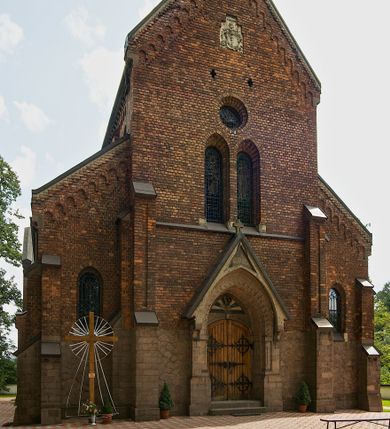 Zdjęcie nr 1: Murowana z cegły, orientowana, trzynawowa bazylika emporowa z prezbiterium zamkniętym trójbocznie. Do jednej czwartej wysokości murów lico kamienne, całość obiega cokół. Fasada dwukondygnacyjna, trójosiowa; oś środkowa wysunięta przed lico muru. Podziały pionowe tworzą dwuuskokowe przypory, poziome gzyms w połowie wysokości osi środkowej. Na osi portal ostrołukowy, uskokowy, flankowany filarami wspartymi na wysokich cokołach. W filarach fragmenty laski. Powyżej wsporniki podtrzymujące wąską archiwoltę otoczoną fryzem arkadowym. Nad otworem drzwiowym tympanon o zarysie łuku ostrego. W zwieńczeniu trójkątny przyczółek, którego ramiona spływają na konsolki oparte na filarach; całość wieńczy krzyż. Ponad portalem dwa okna w uskokowym obramieniu zakończonym łukiem ostrym. Ponad nimi okrągłe okno, wyżej kamienny kartusz z herbem fundatorki. Fasadę wieńczy ząbkowanie i fryz arkadowy. W skrajnych osiach okna ostrołukowe. W dolnym, lewym rogu osi środkowej data: MCMV. Podziały ścian nawy bocznej stanowią trójskokowe przypory; pomiędzy nimi okna ostrołukowe w uskokowych obramieniach. Ponad oknami ząbkowanie, profilowany architraw, fryz i gzyms wsparty na kroksztynach. W partii nawy głównej podział ścian tworzą małe przypory, pomiędzy którymi znajdują się okrągłe okna, ponad nimi fryz arkadowy. W zwieńczeniu kroksztyny. W ścianach zakrystii dwa wąskie, ostrołukowe okna i jedno okrągłe w profilowanych obramieniach. W trójkątnym zwieńczeniu fryz arkadowy ujęty w dwa pasy ząbkowania. Przy zachodniej ścianie południowej zakrystii znajduje się boczne wejście otwarte dwoma ostrołukowymi arkadami, wspartymi na filarze. W górnej partii ozdobione fryzem arkadowym, ząbkowaniem i kroksztynami. Pomiędzy nawą boczną a południową zakrystią okrągła wieżyczka z dwoma kwadratowymi otworami okiennymi. Strona północna analogiczna do południowej, oprócz pomieszczenia między nawą a zakrystią i portalu w pomieszczeniu przy kruchcie. Pomieszczenie z wejściem pomocniczym od strony zachodniej Od północy wąskie okno zamknięte łukiem półkolistym, w narożach ryzality zwieńczone konsolkami z fryzem arkadowym i gzymsem pomiędzy. Portal kamienny, ustawiony na czterech stopniach, ostrołukowy, zwieńczony trójkątnym przyczółkiem z ramionami spływającymi na profilowane konsole. Prezbiterium opięte czterema przyporami dwuuskokowymi. W ścianie wschodniej płycina zakończona łukiem ostrym. W zwieńczeniu fryz arkadowy i gzyms wsparty na kroksztynach. Pomiędzy nawą główną, a prezbiterium wieżyczka na sygnaturkę na planie kwadratu ze ściętymi narożami, przy których znajdują się dwuuskokowe przypory. We wszystkich ścianach wieżyczki po dwa okna ostrołukowe z parapetem, pod nim fryz arkadowy. Ściany wieńczy pas kostkowania. Nawa główna, część prezbiterium i zakrystie przykrywa dach dwuspadowy, z zakończeniu prezbiterium dach powtarza kształt prezbiterium. Nawy boczne nakryte dachem pulpitowym, wieżyczka dachem stożkowym, wieżyczka na sygnaturkę ostrosłupowym ze ściętymi krawędziami. Wszystkie dachy blaszane.Najcenniejszy wyposażenie wnętrza stanowią trzy późnobarokowe ołtarze z 1710 roku (w głównym obraz św. Marii Magdaleny z początku XVIII wieku w sukience z 1709 roku,) ambona z 1711 oraz chrzcielnica czarnomarmurowa z 1751 roku.