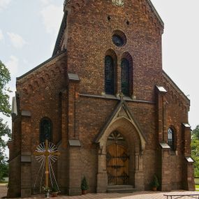 Zdjęcie nr 1: Murowana z cegły, orientowana, trzynawowa bazylika emporowa z prezbiterium zamkniętym trójbocznie. Do jednej czwartej wysokości murów lico kamienne, całość obiega cokół. Fasada dwukondygnacyjna, trójosiowa; oś środkowa wysunięta przed lico muru. Podziały pionowe tworzą dwuuskokowe przypory, poziome gzyms w połowie wysokości osi środkowej. Na osi portal ostrołukowy, uskokowy, flankowany filarami wspartymi na wysokich cokołach. W filarach fragmenty laski. Powyżej wsporniki podtrzymujące wąską archiwoltę otoczoną fryzem arkadowym. Nad otworem drzwiowym tympanon o zarysie łuku ostrego. W zwieńczeniu trójkątny przyczółek, którego ramiona spływają na konsolki oparte na filarach; całość wieńczy krzyż. Ponad portalem dwa okna w uskokowym obramieniu zakończonym łukiem ostrym. Ponad nimi okrągłe okno, wyżej kamienny kartusz z herbem fundatorki. Fasadę wieńczy ząbkowanie i fryz arkadowy. W skrajnych osiach okna ostrołukowe. W dolnym, lewym rogu osi środkowej data: MCMV. Podziały ścian nawy bocznej stanowią trójskokowe przypory; pomiędzy nimi okna ostrołukowe w uskokowych obramieniach. Ponad oknami ząbkowanie, profilowany architraw, fryz i gzyms wsparty na kroksztynach. W partii nawy głównej podział ścian tworzą małe przypory, pomiędzy którymi znajdują się okrągłe okna, ponad nimi fryz arkadowy. W zwieńczeniu kroksztyny. W ścianach zakrystii dwa wąskie, ostrołukowe okna i jedno okrągłe w profilowanych obramieniach. W trójkątnym zwieńczeniu fryz arkadowy ujęty w dwa pasy ząbkowania. Przy zachodniej ścianie południowej zakrystii znajduje się boczne wejście otwarte dwoma ostrołukowymi arkadami, wspartymi na filarze. W górnej partii ozdobione fryzem arkadowym, ząbkowaniem i kroksztynami. Pomiędzy nawą boczną a południową zakrystią okrągła wieżyczka z dwoma kwadratowymi otworami okiennymi. Strona północna analogiczna do południowej, oprócz pomieszczenia między nawą a zakrystią i portalu w pomieszczeniu przy kruchcie. Pomieszczenie z wejściem pomocniczym od strony zachodniej Od północy wąskie okno zamknięte łukiem półkolistym, w narożach ryzality zwieńczone konsolkami z fryzem arkadowym i gzymsem pomiędzy. Portal kamienny, ustawiony na czterech stopniach, ostrołukowy, zwieńczony trójkątnym przyczółkiem z ramionami spływającymi na profilowane konsole. Prezbiterium opięte czterema przyporami dwuuskokowymi. W ścianie wschodniej płycina zakończona łukiem ostrym. W zwieńczeniu fryz arkadowy i gzyms wsparty na kroksztynach. Pomiędzy nawą główną, a prezbiterium wieżyczka na sygnaturkę na planie kwadratu ze ściętymi narożami, przy których znajdują się dwuuskokowe przypory. We wszystkich ścianach wieżyczki po dwa okna ostrołukowe z parapetem, pod nim fryz arkadowy. Ściany wieńczy pas kostkowania. Nawa główna, część prezbiterium i zakrystie przykrywa dach dwuspadowy, z zakończeniu prezbiterium dach powtarza kształt prezbiterium. Nawy boczne nakryte dachem pulpitowym, wieżyczka dachem stożkowym, wieżyczka na sygnaturkę ostrosłupowym ze ściętymi krawędziami. Wszystkie dachy blaszane.Najcenniejszy wyposażenie wnętrza stanowią trzy późnobarokowe ołtarze z 1710 roku (w głównym obraz św. Marii Magdaleny z początku XVIII wieku w sukience z 1709 roku,) ambona z 1711 oraz chrzcielnica czarnomarmurowa z 1751 roku.