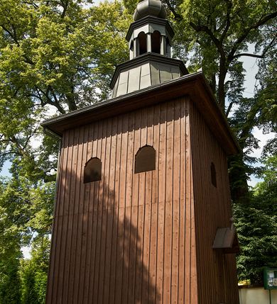 Zdjęcie nr 16: Murowana z cegły, orientowana, trzynawowa bazylika emporowa z prezbiterium zamkniętym trójbocznie. Do jednej czwartej wysokości murów lico kamienne, całość obiega cokół. Fasada dwukondygnacyjna, trójosiowa; oś środkowa wysunięta przed lico muru. Podziały pionowe tworzą dwuuskokowe przypory, poziome gzyms w połowie wysokości osi środkowej. Na osi portal ostrołukowy, uskokowy, flankowany filarami wspartymi na wysokich cokołach. W filarach fragmenty laski. Powyżej wsporniki podtrzymujące wąską archiwoltę otoczoną fryzem arkadowym. Nad otworem drzwiowym tympanon o zarysie łuku ostrego. W zwieńczeniu trójkątny przyczółek, którego ramiona spływają na konsolki oparte na filarach; całość wieńczy krzyż. Ponad portalem dwa okna w uskokowym obramieniu zakończonym łukiem ostrym. Ponad nimi okrągłe okno, wyżej kamienny kartusz z herbem fundatorki. Fasadę wieńczy ząbkowanie i fryz arkadowy. W skrajnych osiach okna ostrołukowe. W dolnym, lewym rogu osi środkowej data: MCMV. Podziały ścian nawy bocznej stanowią trójskokowe przypory; pomiędzy nimi okna ostrołukowe w uskokowych obramieniach. Ponad oknami ząbkowanie, profilowany architraw, fryz i gzyms wsparty na kroksztynach. W partii nawy głównej podział ścian tworzą małe przypory, pomiędzy którymi znajdują się okrągłe okna, ponad nimi fryz arkadowy. W zwieńczeniu kroksztyny. W ścianach zakrystii dwa wąskie, ostrołukowe okna i jedno okrągłe w profilowanych obramieniach. W trójkątnym zwieńczeniu fryz arkadowy ujęty w dwa pasy ząbkowania. Przy zachodniej ścianie południowej zakrystii znajduje się boczne wejście otwarte dwoma ostrołukowymi arkadami, wspartymi na filarze. W górnej partii ozdobione fryzem arkadowym, ząbkowaniem i kroksztynami. Pomiędzy nawą boczną a południową zakrystią okrągła wieżyczka z dwoma kwadratowymi otworami okiennymi. Strona północna analogiczna do południowej, oprócz pomieszczenia między nawą a zakrystią i portalu w pomieszczeniu przy kruchcie. Pomieszczenie z wejściem pomocniczym od strony zachodniej Od północy wąskie okno zamknięte łukiem półkolistym, w narożach ryzality zwieńczone konsolkami z fryzem arkadowym i gzymsem pomiędzy. Portal kamienny, ustawiony na czterech stopniach, ostrołukowy, zwieńczony trójkątnym przyczółkiem z ramionami spływającymi na profilowane konsole. Prezbiterium opięte czterema przyporami dwuuskokowymi. W ścianie wschodniej płycina zakończona łukiem ostrym. W zwieńczeniu fryz arkadowy i gzyms wsparty na kroksztynach. Pomiędzy nawą główną, a prezbiterium wieżyczka na sygnaturkę na planie kwadratu ze ściętymi narożami, przy których znajdują się dwuuskokowe przypory. We wszystkich ścianach wieżyczki po dwa okna ostrołukowe z parapetem, pod nim fryz arkadowy. Ściany wieńczy pas kostkowania. Nawa główna, część prezbiterium i zakrystie przykrywa dach dwuspadowy, z zakończeniu prezbiterium dach powtarza kształt prezbiterium. Nawy boczne nakryte dachem pulpitowym, wieżyczka dachem stożkowym, wieżyczka na sygnaturkę ostrosłupowym ze ściętymi krawędziami. Wszystkie dachy blaszane.Najcenniejszy wyposażenie wnętrza stanowią trzy późnobarokowe ołtarze z 1710 roku (w głównym obraz św. Marii Magdaleny z początku XVIII wieku w sukience z 1709 roku,) ambona z 1711 oraz chrzcielnica czarnomarmurowa z 1751 roku.