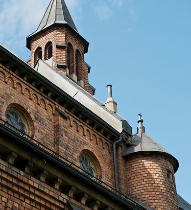 Zdjęcie nr 9: Murowana z cegły, orientowana, trzynawowa bazylika emporowa z prezbiterium zamkniętym trójbocznie. Do jednej czwartej wysokości murów lico kamienne, całość obiega cokół. Fasada dwukondygnacyjna, trójosiowa; oś środkowa wysunięta przed lico muru. Podziały pionowe tworzą dwuuskokowe przypory, poziome gzyms w połowie wysokości osi środkowej. Na osi portal ostrołukowy, uskokowy, flankowany filarami wspartymi na wysokich cokołach. W filarach fragmenty laski. Powyżej wsporniki podtrzymujące wąską archiwoltę otoczoną fryzem arkadowym. Nad otworem drzwiowym tympanon o zarysie łuku ostrego. W zwieńczeniu trójkątny przyczółek, którego ramiona spływają na konsolki oparte na filarach; całość wieńczy krzyż. Ponad portalem dwa okna w uskokowym obramieniu zakończonym łukiem ostrym. Ponad nimi okrągłe okno, wyżej kamienny kartusz z herbem fundatorki. Fasadę wieńczy ząbkowanie i fryz arkadowy. W skrajnych osiach okna ostrołukowe. W dolnym, lewym rogu osi środkowej data: MCMV. Podziały ścian nawy bocznej stanowią trójskokowe przypory; pomiędzy nimi okna ostrołukowe w uskokowych obramieniach. Ponad oknami ząbkowanie, profilowany architraw, fryz i gzyms wsparty na kroksztynach. W partii nawy głównej podział ścian tworzą małe przypory, pomiędzy którymi znajdują się okrągłe okna, ponad nimi fryz arkadowy. W zwieńczeniu kroksztyny. W ścianach zakrystii dwa wąskie, ostrołukowe okna i jedno okrągłe w profilowanych obramieniach. W trójkątnym zwieńczeniu fryz arkadowy ujęty w dwa pasy ząbkowania. Przy zachodniej ścianie południowej zakrystii znajduje się boczne wejście otwarte dwoma ostrołukowymi arkadami, wspartymi na filarze. W górnej partii ozdobione fryzem arkadowym, ząbkowaniem i kroksztynami. Pomiędzy nawą boczną a południową zakrystią okrągła wieżyczka z dwoma kwadratowymi otworami okiennymi. Strona północna analogiczna do południowej, oprócz pomieszczenia między nawą a zakrystią i portalu w pomieszczeniu przy kruchcie. Pomieszczenie z wejściem pomocniczym od strony zachodniej Od północy wąskie okno zamknięte łukiem półkolistym, w narożach ryzality zwieńczone konsolkami z fryzem arkadowym i gzymsem pomiędzy. Portal kamienny, ustawiony na czterech stopniach, ostrołukowy, zwieńczony trójkątnym przyczółkiem z ramionami spływającymi na profilowane konsole. Prezbiterium opięte czterema przyporami dwuuskokowymi. W ścianie wschodniej płycina zakończona łukiem ostrym. W zwieńczeniu fryz arkadowy i gzyms wsparty na kroksztynach. Pomiędzy nawą główną, a prezbiterium wieżyczka na sygnaturkę na planie kwadratu ze ściętymi narożami, przy których znajdują się dwuuskokowe przypory. We wszystkich ścianach wieżyczki po dwa okna ostrołukowe z parapetem, pod nim fryz arkadowy. Ściany wieńczy pas kostkowania. Nawa główna, część prezbiterium i zakrystie przykrywa dach dwuspadowy, z zakończeniu prezbiterium dach powtarza kształt prezbiterium. Nawy boczne nakryte dachem pulpitowym, wieżyczka dachem stożkowym, wieżyczka na sygnaturkę ostrosłupowym ze ściętymi krawędziami. Wszystkie dachy blaszane.Najcenniejszy wyposażenie wnętrza stanowią trzy późnobarokowe ołtarze z 1710 roku (w głównym obraz św. Marii Magdaleny z początku XVIII wieku w sukience z 1709 roku,) ambona z 1711 oraz chrzcielnica czarnomarmurowa z 1751 roku.