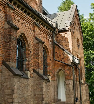 Zdjęcie nr 11: Murowana z cegły, orientowana, trzynawowa bazylika emporowa z prezbiterium zamkniętym trójbocznie. Do jednej czwartej wysokości murów lico kamienne, całość obiega cokół. Fasada dwukondygnacyjna, trójosiowa; oś środkowa wysunięta przed lico muru. Podziały pionowe tworzą dwuuskokowe przypory, poziome gzyms w połowie wysokości osi środkowej. Na osi portal ostrołukowy, uskokowy, flankowany filarami wspartymi na wysokich cokołach. W filarach fragmenty laski. Powyżej wsporniki podtrzymujące wąską archiwoltę otoczoną fryzem arkadowym. Nad otworem drzwiowym tympanon o zarysie łuku ostrego. W zwieńczeniu trójkątny przyczółek, którego ramiona spływają na konsolki oparte na filarach; całość wieńczy krzyż. Ponad portalem dwa okna w uskokowym obramieniu zakończonym łukiem ostrym. Ponad nimi okrągłe okno, wyżej kamienny kartusz z herbem fundatorki. Fasadę wieńczy ząbkowanie i fryz arkadowy. W skrajnych osiach okna ostrołukowe. W dolnym, lewym rogu osi środkowej data: MCMV. Podziały ścian nawy bocznej stanowią trójskokowe przypory; pomiędzy nimi okna ostrołukowe w uskokowych obramieniach. Ponad oknami ząbkowanie, profilowany architraw, fryz i gzyms wsparty na kroksztynach. W partii nawy głównej podział ścian tworzą małe przypory, pomiędzy którymi znajdują się okrągłe okna, ponad nimi fryz arkadowy. W zwieńczeniu kroksztyny. W ścianach zakrystii dwa wąskie, ostrołukowe okna i jedno okrągłe w profilowanych obramieniach. W trójkątnym zwieńczeniu fryz arkadowy ujęty w dwa pasy ząbkowania. Przy zachodniej ścianie południowej zakrystii znajduje się boczne wejście otwarte dwoma ostrołukowymi arkadami, wspartymi na filarze. W górnej partii ozdobione fryzem arkadowym, ząbkowaniem i kroksztynami. Pomiędzy nawą boczną a południową zakrystią okrągła wieżyczka z dwoma kwadratowymi otworami okiennymi. Strona północna analogiczna do południowej, oprócz pomieszczenia między nawą a zakrystią i portalu w pomieszczeniu przy kruchcie. Pomieszczenie z wejściem pomocniczym od strony zachodniej Od północy wąskie okno zamknięte łukiem półkolistym, w narożach ryzality zwieńczone konsolkami z fryzem arkadowym i gzymsem pomiędzy. Portal kamienny, ustawiony na czterech stopniach, ostrołukowy, zwieńczony trójkątnym przyczółkiem z ramionami spływającymi na profilowane konsole. Prezbiterium opięte czterema przyporami dwuuskokowymi. W ścianie wschodniej płycina zakończona łukiem ostrym. W zwieńczeniu fryz arkadowy i gzyms wsparty na kroksztynach. Pomiędzy nawą główną, a prezbiterium wieżyczka na sygnaturkę na planie kwadratu ze ściętymi narożami, przy których znajdują się dwuuskokowe przypory. We wszystkich ścianach wieżyczki po dwa okna ostrołukowe z parapetem, pod nim fryz arkadowy. Ściany wieńczy pas kostkowania. Nawa główna, część prezbiterium i zakrystie przykrywa dach dwuspadowy, z zakończeniu prezbiterium dach powtarza kształt prezbiterium. Nawy boczne nakryte dachem pulpitowym, wieżyczka dachem stożkowym, wieżyczka na sygnaturkę ostrosłupowym ze ściętymi krawędziami. Wszystkie dachy blaszane.Najcenniejszy wyposażenie wnętrza stanowią trzy późnobarokowe ołtarze z 1710 roku (w głównym obraz św. Marii Magdaleny z początku XVIII wieku w sukience z 1709 roku,) ambona z 1711 oraz chrzcielnica czarnomarmurowa z 1751 roku.