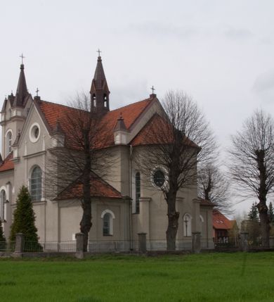 Zdjęcie nr 12: Kościół na planie krzyża łacińskiego, jednonawowy, pięcioprzęsłowy, z transeptem i jednoprzęsłowym prezbiterium zakończonym wielobocznie. Ramiona transeptu jednoprzęsłowe, o wysokości nawy, zamknięte prostymi ścianami. W narożnikach pomiędzy prezbiterium i ramionami transeptu dwa prostokątne aneksy mieszczące zakrystię i skarbiec. Prezbiterium i ramiona transeptu oddzielone od nawy wydatnymi półfilarami przechodzącymi bezpośrednio w gurty sklepienne. Prezbiterium od absydy oddziela arkada tęczowa wsparta na dostawionych do węgarów kolumnach kompozytowych. Sklepienie nad skrzyżowaniem naw krzyżowe, nad pozostałymi przęsłami nawy kolebkowe o przekroju koszowym, nad ramionami transeptu krzyżowe (ostrołukowe), w absydzie ćwierćsferyczne z lunetami. Otwory okienne prostokątne, zamknięte półkoliście, rozglifione do wewnątrz; trzy pary w nawie, dwa na ścianach zamykających ramiona transeptu. Ponad oknami w transepcie dodatkowo po jednym okrągłym oknie wypełnionym rozetą. W prezbiterium okna w kształcie wydłużonego prostokąta o smukłych proporcjach zamkniętego półkoliście, pomiędzy nimi para regularnie rozmieszczonych okien owalnych.  W zachodnim przęśle nawy murowany trójprzęsłowy chór muzyczny wsparty na parze ośmiobocznych filarów z cokołami, a pod ścianami na parze półfilarów. Balustrada o prostej dekoracji płycinowej. Podniebie chóru podzielone belkami na trzy kasetony, pośrodku których kwadratowe płyciny. Fasada kościoła dwukondygnacyjna, trójosiowa przechodząca w czworoboczną wieżę. Ściany rozczłonkowane lizenami, kondygnacje oddzielone profilowanym gzymsem. W części środkowej wejście zamknięte łukiem półkolistym, z dwuspadowym drewnianym daszkiem, wyżej prostokątne okno zamknięte półkoliście. W polach bocznych mniejsze, prostokątne okna zamknięte półkoliście. Wieża o narożach ujętych lizenami, podtrzymującymi gzyms, nakryta ozdobnym zwieńczeniem z czterema wieżyczkami w narożach, pomiędzy którymi trójkątne szczyciki nad oknami i ostrosłupowy hełm zakończony krzyżem. Ściany boczne nawy i transeptu ujęte uskokowymi przyporami. Ściany zamykające ramiona transeptu podzielone na dwie strefy, z których dolna ujęta lizenami, górna wypełniona oknem w ozdobnym obramieniu. Dachy dwuspadowe, kryte dachówką. Na skrzyżowaniu naw wieloboczna, drewniana wieżyczka na sygnaturkę nakryta ostrosłupowym hełmem pokrytym blachą.

