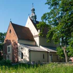 Zdjęcie nr 1: Budynek orientowany, jednonawowy. Prostokątna nawa jest szersza i znacznie wyższa, oddzielona od prezbiterium za pomocą ściany tarczowej z ostrołukową arkadą tęczową. Przy prezbiterium od północy zakrystia na planie prostokąta i taki sam skarbczyk, od południa niewielka, prostokątna kruchta. Przy nawie od południa podłużna kaplica Matki Boskiej Szkaplerznej (1741) z kwadratową kruchtą od zachodu; od północy kaplica Matki Boskiej Bolesnej na planie półokręgu z obejściem (1919-1932, projektu Bogdana Tretera). Prezbiterium sklepione krzyżowo-żebrowo, korpus sześciodzielnie, z gurtami. 
Okna nawy i kaplicy południowej ostrołukowe; w zwieńczeniu zakrystii jedno okno okrągłe; w kaplicy południowej okna zamknięte półkoliście, w kopule lukarny z eliptycznymi otworami okiennymi. 
Główne wejście od zachodu, ostrołukowe, drugie przez kruchtę od północy, w kształcie stojącego prostokąta. Portal z prezbiterium do zakrystii kamienny, profilowany zamknięty ściętym trójliściem (XV/XVI w.); portal z kruchty północnej do kaplicy kamienny, ostrołukowy, profilowany i fazowany, nad nim późnogotycka tarcza z herbem Nieczuja. Nad zewnętrznym, ostrołukowym portalem do kruchty północnej herb Korab i insygnia biskupa Jakuba Zadzika, pochodzące prawdopodobnie z dawnej bramy przejazdowej obok katedry w Kielcach. 
Na zewnątrz budynek opięty przyporami o zmiennym profilu. Elewacje, z wyjątkiem wschodniej ściany prezbiterium, tynkowane. Fasada zamknięta wysokim, trójkątnym szczytem, trójosiowa. W osi środkowej kamienny, ostrołukowy portal. W osiach bocznych ostrołukowe okna. Narożniki ujęte modelowanymi w tynku lizenami oraz przyporami. Powyżej na ich osiach prostopadłościenne sterczyny zwieńczone krzyżami. Elewacja wschodnia o analogicznym układzie, ceglana, nietynkowana, ujęta skośnie ustawionymi przyporami, jednoosiowa. W osi szeroka, jednouskokowa przypora z kamienną płyciną mieszczącą krucyfiks w dolnej części i analogiczną, mniejszą z kamienną figurą św. Piotra na tle okna powyżej. Na ścianie szczytowej cegły ułożone w jodełkę, w górnej części ostrołukowa, uskokowa płycina. Na zwieńczeniu wyryty napis „RENO/VATUM / A(NNO) D(OMINI)/ 1928”.  Elewacja północna z dobudowanymi na całej długości zakrystią, skarbczykiem i kaplicą. Elewacja południowa tynkowana, w części prezbiterium dwuosiowa; w narożniku pomiędzy prezbiterium a nawą niewielka kruchta. Do korpusu dobudowana kaplica – z tynkowanymi elewacjami o osiach podkreślonych lizenami, zróżnicowanymi kolorystycznie. Dach nad korpusem nawowym i prezbiterium dwuspadowy, nad zakrystią i skarbczykiem dachy pulpitowe –  kryte dachówką. Kaplica południowa nakryta kopułą z lunetami i latarnią – kryta blachą. Wieżyczka na sygnaturkę o formach barokowych z latarnią.