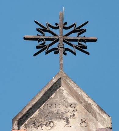 Zdjęcie nr 8: Budynek orientowany, jednonawowy. Prostokątna nawa jest szersza i znacznie wyższa, oddzielona od prezbiterium za pomocą ściany tarczowej z ostrołukową arkadą tęczową. Przy prezbiterium od północy zakrystia na planie prostokąta i taki sam skarbczyk, od południa niewielka, prostokątna kruchta. Przy nawie od południa podłużna kaplica Matki Boskiej Szkaplerznej (1741) z kwadratową kruchtą od zachodu; od północy kaplica Matki Boskiej Bolesnej na planie półokręgu z obejściem (1919-1932, projektu Bogdana Tretera). Prezbiterium sklepione krzyżowo-żebrowo, korpus sześciodzielnie, z gurtami. 
Okna nawy i kaplicy południowej ostrołukowe; w zwieńczeniu zakrystii jedno okno okrągłe; w kaplicy południowej okna zamknięte półkoliście, w kopule lukarny z eliptycznymi otworami okiennymi. 
Główne wejście od zachodu, ostrołukowe, drugie przez kruchtę od północy, w kształcie stojącego prostokąta. Portal z prezbiterium do zakrystii kamienny, profilowany zamknięty ściętym trójliściem (XV/XVI w.); portal z kruchty północnej do kaplicy kamienny, ostrołukowy, profilowany i fazowany, nad nim późnogotycka tarcza z herbem Nieczuja. Nad zewnętrznym, ostrołukowym portalem do kruchty północnej herb Korab i insygnia biskupa Jakuba Zadzika, pochodzące prawdopodobnie z dawnej bramy przejazdowej obok katedry w Kielcach. 
Na zewnątrz budynek opięty przyporami o zmiennym profilu. Elewacje, z wyjątkiem wschodniej ściany prezbiterium, tynkowane. Fasada zamknięta wysokim, trójkątnym szczytem, trójosiowa. W osi środkowej kamienny, ostrołukowy portal. W osiach bocznych ostrołukowe okna. Narożniki ujęte modelowanymi w tynku lizenami oraz przyporami. Powyżej na ich osiach prostopadłościenne sterczyny zwieńczone krzyżami. Elewacja wschodnia o analogicznym układzie, ceglana, nietynkowana, ujęta skośnie ustawionymi przyporami, jednoosiowa. W osi szeroka, jednouskokowa przypora z kamienną płyciną mieszczącą krucyfiks w dolnej części i analogiczną, mniejszą z kamienną figurą św. Piotra na tle okna powyżej. Na ścianie szczytowej cegły ułożone w jodełkę, w górnej części ostrołukowa, uskokowa płycina. Na zwieńczeniu wyryty napis „RENO/VATUM / A(NNO) D(OMINI)/ 1928”.  Elewacja północna z dobudowanymi na całej długości zakrystią, skarbczykiem i kaplicą. Elewacja południowa tynkowana, w części prezbiterium dwuosiowa; w narożniku pomiędzy prezbiterium a nawą niewielka kruchta. Do korpusu dobudowana kaplica – z tynkowanymi elewacjami o osiach podkreślonych lizenami, zróżnicowanymi kolorystycznie. Dach nad korpusem nawowym i prezbiterium dwuspadowy, nad zakrystią i skarbczykiem dachy pulpitowe –  kryte dachówką. Kaplica południowa nakryta kopułą z lunetami i latarnią – kryta blachą. Wieżyczka na sygnaturkę o formach barokowych z latarnią.