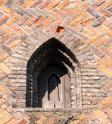 Zdjęcie nr 7: Budynek orientowany, jednonawowy. Prostokątna nawa jest szersza i znacznie wyższa, oddzielona od prezbiterium za pomocą ściany tarczowej z ostrołukową arkadą tęczową. Przy prezbiterium od północy zakrystia na planie prostokąta i taki sam skarbczyk, od południa niewielka, prostokątna kruchta. Przy nawie od południa podłużna kaplica Matki Boskiej Szkaplerznej (1741) z kwadratową kruchtą od zachodu; od północy kaplica Matki Boskiej Bolesnej na planie półokręgu z obejściem (1919-1932, projektu Bogdana Tretera). Prezbiterium sklepione krzyżowo-żebrowo, korpus sześciodzielnie, z gurtami. 
Okna nawy i kaplicy południowej ostrołukowe; w zwieńczeniu zakrystii jedno okno okrągłe; w kaplicy południowej okna zamknięte półkoliście, w kopule lukarny z eliptycznymi otworami okiennymi. 
Główne wejście od zachodu, ostrołukowe, drugie przez kruchtę od północy, w kształcie stojącego prostokąta. Portal z prezbiterium do zakrystii kamienny, profilowany zamknięty ściętym trójliściem (XV/XVI w.); portal z kruchty północnej do kaplicy kamienny, ostrołukowy, profilowany i fazowany, nad nim późnogotycka tarcza z herbem Nieczuja. Nad zewnętrznym, ostrołukowym portalem do kruchty północnej herb Korab i insygnia biskupa Jakuba Zadzika, pochodzące prawdopodobnie z dawnej bramy przejazdowej obok katedry w Kielcach. 
Na zewnątrz budynek opięty przyporami o zmiennym profilu. Elewacje, z wyjątkiem wschodniej ściany prezbiterium, tynkowane. Fasada zamknięta wysokim, trójkątnym szczytem, trójosiowa. W osi środkowej kamienny, ostrołukowy portal. W osiach bocznych ostrołukowe okna. Narożniki ujęte modelowanymi w tynku lizenami oraz przyporami. Powyżej na ich osiach prostopadłościenne sterczyny zwieńczone krzyżami. Elewacja wschodnia o analogicznym układzie, ceglana, nietynkowana, ujęta skośnie ustawionymi przyporami, jednoosiowa. W osi szeroka, jednouskokowa przypora z kamienną płyciną mieszczącą krucyfiks w dolnej części i analogiczną, mniejszą z kamienną figurą św. Piotra na tle okna powyżej. Na ścianie szczytowej cegły ułożone w jodełkę, w górnej części ostrołukowa, uskokowa płycina. Na zwieńczeniu wyryty napis „RENO/VATUM / A(NNO) D(OMINI)/ 1928”.  Elewacja północna z dobudowanymi na całej długości zakrystią, skarbczykiem i kaplicą. Elewacja południowa tynkowana, w części prezbiterium dwuosiowa; w narożniku pomiędzy prezbiterium a nawą niewielka kruchta. Do korpusu dobudowana kaplica – z tynkowanymi elewacjami o osiach podkreślonych lizenami, zróżnicowanymi kolorystycznie. Dach nad korpusem nawowym i prezbiterium dwuspadowy, nad zakrystią i skarbczykiem dachy pulpitowe –  kryte dachówką. Kaplica południowa nakryta kopułą z lunetami i latarnią – kryta blachą. Wieżyczka na sygnaturkę o formach barokowych z latarnią.