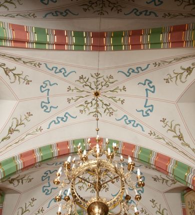 Zdjęcie nr 28: Budynek orientowany, jednonawowy. Prostokątna nawa jest szersza i znacznie wyższa, oddzielona od prezbiterium za pomocą ściany tarczowej z ostrołukową arkadą tęczową. Przy prezbiterium od północy zakrystia na planie prostokąta i taki sam skarbczyk, od południa niewielka, prostokątna kruchta. Przy nawie od południa podłużna kaplica Matki Boskiej Szkaplerznej (1741) z kwadratową kruchtą od zachodu; od północy kaplica Matki Boskiej Bolesnej na planie półokręgu z obejściem (1919-1932, projektu Bogdana Tretera). Prezbiterium sklepione krzyżowo-żebrowo, korpus sześciodzielnie, z gurtami. 
Okna nawy i kaplicy południowej ostrołukowe; w zwieńczeniu zakrystii jedno okno okrągłe; w kaplicy południowej okna zamknięte półkoliście, w kopule lukarny z eliptycznymi otworami okiennymi. 
Główne wejście od zachodu, ostrołukowe, drugie przez kruchtę od północy, w kształcie stojącego prostokąta. Portal z prezbiterium do zakrystii kamienny, profilowany zamknięty ściętym trójliściem (XV/XVI w.); portal z kruchty północnej do kaplicy kamienny, ostrołukowy, profilowany i fazowany, nad nim późnogotycka tarcza z herbem Nieczuja. Nad zewnętrznym, ostrołukowym portalem do kruchty północnej herb Korab i insygnia biskupa Jakuba Zadzika, pochodzące prawdopodobnie z dawnej bramy przejazdowej obok katedry w Kielcach. 
Na zewnątrz budynek opięty przyporami o zmiennym profilu. Elewacje, z wyjątkiem wschodniej ściany prezbiterium, tynkowane. Fasada zamknięta wysokim, trójkątnym szczytem, trójosiowa. W osi środkowej kamienny, ostrołukowy portal. W osiach bocznych ostrołukowe okna. Narożniki ujęte modelowanymi w tynku lizenami oraz przyporami. Powyżej na ich osiach prostopadłościenne sterczyny zwieńczone krzyżami. Elewacja wschodnia o analogicznym układzie, ceglana, nietynkowana, ujęta skośnie ustawionymi przyporami, jednoosiowa. W osi szeroka, jednouskokowa przypora z kamienną płyciną mieszczącą krucyfiks w dolnej części i analogiczną, mniejszą z kamienną figurą św. Piotra na tle okna powyżej. Na ścianie szczytowej cegły ułożone w jodełkę, w górnej części ostrołukowa, uskokowa płycina. Na zwieńczeniu wyryty napis „RENO/VATUM / A(NNO) D(OMINI)/ 1928”.  Elewacja północna z dobudowanymi na całej długości zakrystią, skarbczykiem i kaplicą. Elewacja południowa tynkowana, w części prezbiterium dwuosiowa; w narożniku pomiędzy prezbiterium a nawą niewielka kruchta. Do korpusu dobudowana kaplica – z tynkowanymi elewacjami o osiach podkreślonych lizenami, zróżnicowanymi kolorystycznie. Dach nad korpusem nawowym i prezbiterium dwuspadowy, nad zakrystią i skarbczykiem dachy pulpitowe –  kryte dachówką. Kaplica południowa nakryta kopułą z lunetami i latarnią – kryta blachą. Wieżyczka na sygnaturkę o formach barokowych z latarnią.