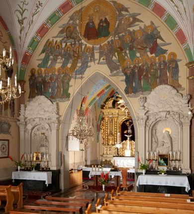 Zdjęcie nr 30: Budynek orientowany, jednonawowy. Prostokątna nawa jest szersza i znacznie wyższa, oddzielona od prezbiterium za pomocą ściany tarczowej z ostrołukową arkadą tęczową. Przy prezbiterium od północy zakrystia na planie prostokąta i taki sam skarbczyk, od południa niewielka, prostokątna kruchta. Przy nawie od południa podłużna kaplica Matki Boskiej Szkaplerznej (1741) z kwadratową kruchtą od zachodu; od północy kaplica Matki Boskiej Bolesnej na planie półokręgu z obejściem (1919-1932, projektu Bogdana Tretera). Prezbiterium sklepione krzyżowo-żebrowo, korpus sześciodzielnie, z gurtami. 
Okna nawy i kaplicy południowej ostrołukowe; w zwieńczeniu zakrystii jedno okno okrągłe; w kaplicy południowej okna zamknięte półkoliście, w kopule lukarny z eliptycznymi otworami okiennymi. 
Główne wejście od zachodu, ostrołukowe, drugie przez kruchtę od północy, w kształcie stojącego prostokąta. Portal z prezbiterium do zakrystii kamienny, profilowany zamknięty ściętym trójliściem (XV/XVI w.); portal z kruchty północnej do kaplicy kamienny, ostrołukowy, profilowany i fazowany, nad nim późnogotycka tarcza z herbem Nieczuja. Nad zewnętrznym, ostrołukowym portalem do kruchty północnej herb Korab i insygnia biskupa Jakuba Zadzika, pochodzące prawdopodobnie z dawnej bramy przejazdowej obok katedry w Kielcach. 
Na zewnątrz budynek opięty przyporami o zmiennym profilu. Elewacje, z wyjątkiem wschodniej ściany prezbiterium, tynkowane. Fasada zamknięta wysokim, trójkątnym szczytem, trójosiowa. W osi środkowej kamienny, ostrołukowy portal. W osiach bocznych ostrołukowe okna. Narożniki ujęte modelowanymi w tynku lizenami oraz przyporami. Powyżej na ich osiach prostopadłościenne sterczyny zwieńczone krzyżami. Elewacja wschodnia o analogicznym układzie, ceglana, nietynkowana, ujęta skośnie ustawionymi przyporami, jednoosiowa. W osi szeroka, jednouskokowa przypora z kamienną płyciną mieszczącą krucyfiks w dolnej części i analogiczną, mniejszą z kamienną figurą św. Piotra na tle okna powyżej. Na ścianie szczytowej cegły ułożone w jodełkę, w górnej części ostrołukowa, uskokowa płycina. Na zwieńczeniu wyryty napis „RENO/VATUM / A(NNO) D(OMINI)/ 1928”.  Elewacja północna z dobudowanymi na całej długości zakrystią, skarbczykiem i kaplicą. Elewacja południowa tynkowana, w części prezbiterium dwuosiowa; w narożniku pomiędzy prezbiterium a nawą niewielka kruchta. Do korpusu dobudowana kaplica – z tynkowanymi elewacjami o osiach podkreślonych lizenami, zróżnicowanymi kolorystycznie. Dach nad korpusem nawowym i prezbiterium dwuspadowy, nad zakrystią i skarbczykiem dachy pulpitowe –  kryte dachówką. Kaplica południowa nakryta kopułą z lunetami i latarnią – kryta blachą. Wieżyczka na sygnaturkę o formach barokowych z latarnią.