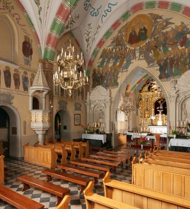 Zdjęcie nr 32: Budynek orientowany, jednonawowy. Prostokątna nawa jest szersza i znacznie wyższa, oddzielona od prezbiterium za pomocą ściany tarczowej z ostrołukową arkadą tęczową. Przy prezbiterium od północy zakrystia na planie prostokąta i taki sam skarbczyk, od południa niewielka, prostokątna kruchta. Przy nawie od południa podłużna kaplica Matki Boskiej Szkaplerznej (1741) z kwadratową kruchtą od zachodu; od północy kaplica Matki Boskiej Bolesnej na planie półokręgu z obejściem (1919-1932, projektu Bogdana Tretera). Prezbiterium sklepione krzyżowo-żebrowo, korpus sześciodzielnie, z gurtami. 
Okna nawy i kaplicy południowej ostrołukowe; w zwieńczeniu zakrystii jedno okno okrągłe; w kaplicy południowej okna zamknięte półkoliście, w kopule lukarny z eliptycznymi otworami okiennymi. 
Główne wejście od zachodu, ostrołukowe, drugie przez kruchtę od północy, w kształcie stojącego prostokąta. Portal z prezbiterium do zakrystii kamienny, profilowany zamknięty ściętym trójliściem (XV/XVI w.); portal z kruchty północnej do kaplicy kamienny, ostrołukowy, profilowany i fazowany, nad nim późnogotycka tarcza z herbem Nieczuja. Nad zewnętrznym, ostrołukowym portalem do kruchty północnej herb Korab i insygnia biskupa Jakuba Zadzika, pochodzące prawdopodobnie z dawnej bramy przejazdowej obok katedry w Kielcach. 
Na zewnątrz budynek opięty przyporami o zmiennym profilu. Elewacje, z wyjątkiem wschodniej ściany prezbiterium, tynkowane. Fasada zamknięta wysokim, trójkątnym szczytem, trójosiowa. W osi środkowej kamienny, ostrołukowy portal. W osiach bocznych ostrołukowe okna. Narożniki ujęte modelowanymi w tynku lizenami oraz przyporami. Powyżej na ich osiach prostopadłościenne sterczyny zwieńczone krzyżami. Elewacja wschodnia o analogicznym układzie, ceglana, nietynkowana, ujęta skośnie ustawionymi przyporami, jednoosiowa. W osi szeroka, jednouskokowa przypora z kamienną płyciną mieszczącą krucyfiks w dolnej części i analogiczną, mniejszą z kamienną figurą św. Piotra na tle okna powyżej. Na ścianie szczytowej cegły ułożone w jodełkę, w górnej części ostrołukowa, uskokowa płycina. Na zwieńczeniu wyryty napis „RENO/VATUM / A(NNO) D(OMINI)/ 1928”.  Elewacja północna z dobudowanymi na całej długości zakrystią, skarbczykiem i kaplicą. Elewacja południowa tynkowana, w części prezbiterium dwuosiowa; w narożniku pomiędzy prezbiterium a nawą niewielka kruchta. Do korpusu dobudowana kaplica – z tynkowanymi elewacjami o osiach podkreślonych lizenami, zróżnicowanymi kolorystycznie. Dach nad korpusem nawowym i prezbiterium dwuspadowy, nad zakrystią i skarbczykiem dachy pulpitowe –  kryte dachówką. Kaplica południowa nakryta kopułą z lunetami i latarnią – kryta blachą. Wieżyczka na sygnaturkę o formach barokowych z latarnią.