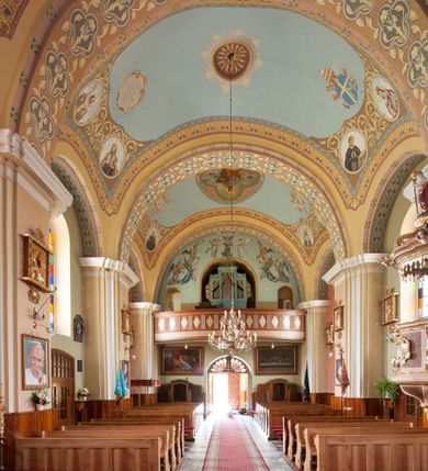 Zdjęcie nr 10: Kościół murowany, orientowany, na planie wydłużonego prostokąta, jednonawowy, trójprzęsłowy. Do prosto zamkniętego prezbiterium przylega na osi zakrystia, od północy kruchta. Ściany artykułowane wewnątrz pilastrami o profilowanych narożach, na pilastry spływają gurty sklepienia, prezbiterium węższe, sklepienie kolebkowe, od zachodu chór z niszą, w której ustawiono organy. Ściany pokrywa polichromia figuralno-ornamentalna z dominującymi kolorami żółtym i niebieskim. Między pilastrami okna w kształcie stojącego prostokąta zamkniętego półkoliście; mniejsze przy chórze. Główne drzwi od wschodu, boczne od północy. 
Fasada trójosiowa, jednokondygnacyjna, zakończona wieżą z hełmem. Osie wydzielone są parami lizen. Na osi wejście w kształcie stojącego prostokąta, powyżej ślepe okno zamknięte półkoliście, naroża zaokrąglone. Powyżej kondygnacja czworobocznej wieży, z czterech stron przeprutej oknami o wykroju jak w fasadzie, przedzielona gzymsem powyżej którego tarcze zegara. Ściany boczne kościoła artykułowane lizenami, okna umieszczone we wnękach. Nawa główna oraz kruchta nakryte dachami dwuspadowymi, prezbiterium oraz zakrystia trójspadowymi, na kalenicy nawy sześcioboczna wieżyczka na sygnaturkę; wieża pokryta dachem czterospadowym z kulą i krzyżem. 
Całe wyposażenie wnętrza pochodzi z drugiej połowy XIX lub z XX wieku, uwagę przyciągają zwłaszcza neobarokowe ołtarze. 
