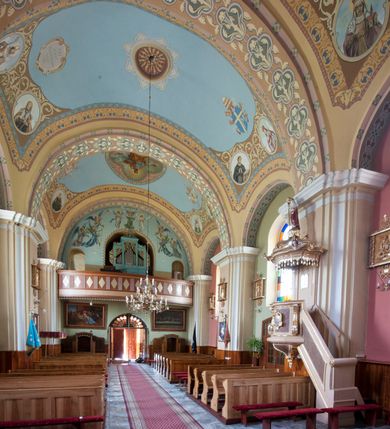 Zdjęcie nr 11: Kościół murowany, orientowany, na planie wydłużonego prostokąta, jednonawowy, trójprzęsłowy. Do prosto zamkniętego prezbiterium przylega na osi zakrystia, od północy kruchta. Ściany artykułowane wewnątrz pilastrami o profilowanych narożach, na pilastry spływają gurty sklepienia, prezbiterium węższe, sklepienie kolebkowe, od zachodu chór z niszą, w której ustawiono organy. Ściany pokrywa polichromia figuralno-ornamentalna z dominującymi kolorami żółtym i niebieskim. Między pilastrami okna w kształcie stojącego prostokąta zamkniętego półkoliście; mniejsze przy chórze. Główne drzwi od wschodu, boczne od północy. 
Fasada trójosiowa, jednokondygnacyjna, zakończona wieżą z hełmem. Osie wydzielone są parami lizen. Na osi wejście w kształcie stojącego prostokąta, powyżej ślepe okno zamknięte półkoliście, naroża zaokrąglone. Powyżej kondygnacja czworobocznej wieży, z czterech stron przeprutej oknami o wykroju jak w fasadzie, przedzielona gzymsem powyżej którego tarcze zegara. Ściany boczne kościoła artykułowane lizenami, okna umieszczone we wnękach. Nawa główna oraz kruchta nakryte dachami dwuspadowymi, prezbiterium oraz zakrystia trójspadowymi, na kalenicy nawy sześcioboczna wieżyczka na sygnaturkę; wieża pokryta dachem czterospadowym z kulą i krzyżem. 
Całe wyposażenie wnętrza pochodzi z drugiej połowy XIX lub z XX wieku, uwagę przyciągają zwłaszcza neobarokowe ołtarze. 
