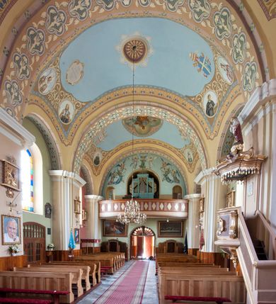 Zdjęcie nr 13: Kościół murowany, orientowany, na planie wydłużonego prostokąta, jednonawowy, trójprzęsłowy. Do prosto zamkniętego prezbiterium przylega na osi zakrystia, od północy kruchta. Ściany artykułowane wewnątrz pilastrami o profilowanych narożach, na pilastry spływają gurty sklepienia, prezbiterium węższe, sklepienie kolebkowe, od zachodu chór z niszą, w której ustawiono organy. Ściany pokrywa polichromia figuralno-ornamentalna z dominującymi kolorami żółtym i niebieskim. Między pilastrami okna w kształcie stojącego prostokąta zamkniętego półkoliście; mniejsze przy chórze. Główne drzwi od wschodu, boczne od północy. 
Fasada trójosiowa, jednokondygnacyjna, zakończona wieżą z hełmem. Osie wydzielone są parami lizen. Na osi wejście w kształcie stojącego prostokąta, powyżej ślepe okno zamknięte półkoliście, naroża zaokrąglone. Powyżej kondygnacja czworobocznej wieży, z czterech stron przeprutej oknami o wykroju jak w fasadzie, przedzielona gzymsem powyżej którego tarcze zegara. Ściany boczne kościoła artykułowane lizenami, okna umieszczone we wnękach. Nawa główna oraz kruchta nakryte dachami dwuspadowymi, prezbiterium oraz zakrystia trójspadowymi, na kalenicy nawy sześcioboczna wieżyczka na sygnaturkę; wieża pokryta dachem czterospadowym z kulą i krzyżem. 
Całe wyposażenie wnętrza pochodzi z drugiej połowy XIX lub z XX wieku, uwagę przyciągają zwłaszcza neobarokowe ołtarze. 
