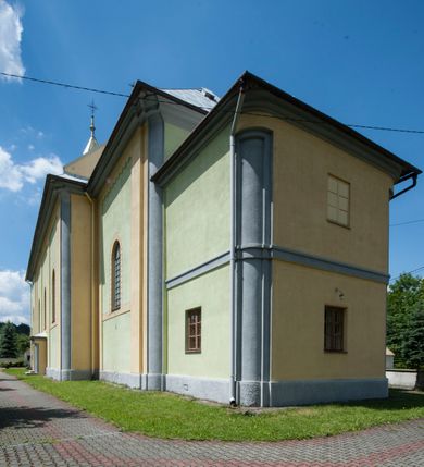 Zdjęcie nr 4: Kościół murowany, orientowany, na planie wydłużonego prostokąta, jednonawowy, trójprzęsłowy. Do prosto zamkniętego prezbiterium przylega na osi zakrystia, od północy kruchta. Ściany artykułowane wewnątrz pilastrami o profilowanych narożach, na pilastry spływają gurty sklepienia, prezbiterium węższe, sklepienie kolebkowe, od zachodu chór z niszą, w której ustawiono organy. Ściany pokrywa polichromia figuralno-ornamentalna z dominującymi kolorami żółtym i niebieskim. Między pilastrami okna w kształcie stojącego prostokąta zamkniętego półkoliście; mniejsze przy chórze. Główne drzwi od wschodu, boczne od północy. 
Fasada trójosiowa, jednokondygnacyjna, zakończona wieżą z hełmem. Osie wydzielone są parami lizen. Na osi wejście w kształcie stojącego prostokąta, powyżej ślepe okno zamknięte półkoliście, naroża zaokrąglone. Powyżej kondygnacja czworobocznej wieży, z czterech stron przeprutej oknami o wykroju jak w fasadzie, przedzielona gzymsem powyżej którego tarcze zegara. Ściany boczne kościoła artykułowane lizenami, okna umieszczone we wnękach. Nawa główna oraz kruchta nakryte dachami dwuspadowymi, prezbiterium oraz zakrystia trójspadowymi, na kalenicy nawy sześcioboczna wieżyczka na sygnaturkę; wieża pokryta dachem czterospadowym z kulą i krzyżem. 
Całe wyposażenie wnętrza pochodzi z drugiej połowy XIX lub z XX wieku, uwagę przyciągają zwłaszcza neobarokowe ołtarze. 
