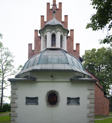 Zdjęcie nr 43: Na miejscu kościoła romańskiego, orientowany, dwunawowy, halowy; nawa południowa na rzucie prostokąta, na osi prezbiterium, dwuprzęsłowa, sklepiona kolebkowo z lunetami, na gurtach; nawa północna węższa od południowej, dwuprzęsłowa, sklepiona krzyżowo-żebrowo z kolistymi płaskorzeźbionymi zwornikami, jeden z literami ihs, drugi z literą s pod koroną. Prezbiterium prostokątne, dwuprzęsłowe, sklepione krzyżowo-żebrowo, z kolistymi zwornikami i profilowanymi wspornikami; przy nim od północy dawna zakrystia na rzucie prostokąta, sklepiona kolebkowo, otwarta do nawy wtórną arkadą, od wschodu nowa zakrystia na rzucie ośmioboku. Od zachodu przylega do nawy kwadratowa, czterokondygnacyjna wieża, z wieżyczką schodową w narożu północno-wschodnim, kruchtą w przyziemiu i chórem muzycznym na piętrze. Przy niej od północy drewniana piętrowa przybudówka mieszcząca w przyziemiu komorę bracką, na piętrze miech i kanał organowy. Przy nawie południowej od południa kwadratowa kruchta. Arkada tęczy zamknięta łukiem półkolistym, arkady do nawy północnej łukiem lekko zaostrzonym. Mury opięte przyporami, elewacje na cokole, z wzorami z zendrówki. Okna pierwotnie ostrołukowe, obustronnie rozglifione (niektóre zbarokizowane). Portale: zachodni, do kruchty pod wieżą, oraz do kruchty południowej, kamienne, prostokątne. Dachy dwuspadowe, pokryte blachą miedzianą. Zakrystia od wschodu przy prezbiterium wzniesiona na miejscu drewnianej kaplicy Ogrojcowej z XVIII wieku.