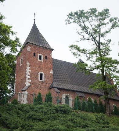 Zdjęcie nr 7: Na miejscu kościoła romańskiego, orientowany, dwunawowy, halowy; nawa południowa na rzucie prostokąta, na osi prezbiterium, dwuprzęsłowa, sklepiona kolebkowo z lunetami, na gurtach; nawa północna węższa od południowej, dwuprzęsłowa, sklepiona krzyżowo-żebrowo z kolistymi płaskorzeźbionymi zwornikami, jeden z literami ihs, drugi z literą s pod koroną. Prezbiterium prostokątne, dwuprzęsłowe, sklepione krzyżowo-żebrowo, z kolistymi zwornikami i profilowanymi wspornikami; przy nim od północy dawna zakrystia na rzucie prostokąta, sklepiona kolebkowo, otwarta do nawy wtórną arkadą, od wschodu nowa zakrystia na rzucie ośmioboku. Od zachodu przylega do nawy kwadratowa, czterokondygnacyjna wieża, z wieżyczką schodową w narożu północno-wschodnim, kruchtą w przyziemiu i chórem muzycznym na piętrze. Przy niej od północy drewniana piętrowa przybudówka mieszcząca w przyziemiu komorę bracką, na piętrze miech i kanał organowy. Przy nawie południowej od południa kwadratowa kruchta. Arkada tęczy zamknięta łukiem półkolistym, arkady do nawy północnej łukiem lekko zaostrzonym. Mury opięte przyporami, elewacje na cokole, z wzorami z zendrówki. Okna pierwotnie ostrołukowe, obustronnie rozglifione (niektóre zbarokizowane). Portale: zachodni, do kruchty pod wieżą, oraz do kruchty południowej, kamienne, prostokątne. Dachy dwuspadowe, pokryte blachą miedzianą. Zakrystia od wschodu przy prezbiterium wzniesiona na miejscu drewnianej kaplicy Ogrojcowej z XVIII wieku.