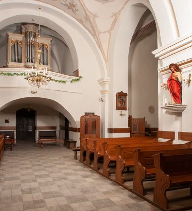 Zdjęcie nr 34: Na miejscu kościoła romańskiego, orientowany, dwunawowy, halowy; nawa południowa na rzucie prostokąta, na osi prezbiterium, dwuprzęsłowa, sklepiona kolebkowo z lunetami, na gurtach; nawa północna węższa od południowej, dwuprzęsłowa, sklepiona krzyżowo-żebrowo z kolistymi płaskorzeźbionymi zwornikami, jeden z literami ihs, drugi z literą s pod koroną. Prezbiterium prostokątne, dwuprzęsłowe, sklepione krzyżowo-żebrowo, z kolistymi zwornikami i profilowanymi wspornikami; przy nim od północy dawna zakrystia na rzucie prostokąta, sklepiona kolebkowo, otwarta do nawy wtórną arkadą, od wschodu nowa zakrystia na rzucie ośmioboku. Od zachodu przylega do nawy kwadratowa, czterokondygnacyjna wieża, z wieżyczką schodową w narożu północno-wschodnim, kruchtą w przyziemiu i chórem muzycznym na piętrze. Przy niej od północy drewniana piętrowa przybudówka mieszcząca w przyziemiu komorę bracką, na piętrze miech i kanał organowy. Przy nawie południowej od południa kwadratowa kruchta. Arkada tęczy zamknięta łukiem półkolistym, arkady do nawy północnej łukiem lekko zaostrzonym. Mury opięte przyporami, elewacje na cokole, z wzorami z zendrówki. Okna pierwotnie ostrołukowe, obustronnie rozglifione (niektóre zbarokizowane). Portale: zachodni, do kruchty pod wieżą, oraz do kruchty południowej, kamienne, prostokątne. Dachy dwuspadowe, pokryte blachą miedzianą. Zakrystia od wschodu przy prezbiterium wzniesiona na miejscu drewnianej kaplicy Ogrojcowej z XVIII wieku.