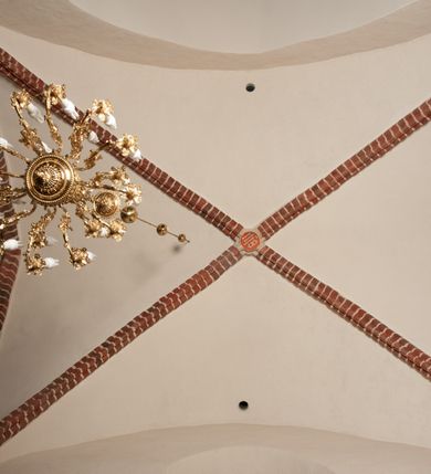 Zdjęcie nr 38: Na miejscu kościoła romańskiego, orientowany, dwunawowy, halowy; nawa południowa na rzucie prostokąta, na osi prezbiterium, dwuprzęsłowa, sklepiona kolebkowo z lunetami, na gurtach; nawa północna węższa od południowej, dwuprzęsłowa, sklepiona krzyżowo-żebrowo z kolistymi płaskorzeźbionymi zwornikami, jeden z literami ihs, drugi z literą s pod koroną. Prezbiterium prostokątne, dwuprzęsłowe, sklepione krzyżowo-żebrowo, z kolistymi zwornikami i profilowanymi wspornikami; przy nim od północy dawna zakrystia na rzucie prostokąta, sklepiona kolebkowo, otwarta do nawy wtórną arkadą, od wschodu nowa zakrystia na rzucie ośmioboku. Od zachodu przylega do nawy kwadratowa, czterokondygnacyjna wieża, z wieżyczką schodową w narożu północno-wschodnim, kruchtą w przyziemiu i chórem muzycznym na piętrze. Przy niej od północy drewniana piętrowa przybudówka mieszcząca w przyziemiu komorę bracką, na piętrze miech i kanał organowy. Przy nawie południowej od południa kwadratowa kruchta. Arkada tęczy zamknięta łukiem półkolistym, arkady do nawy północnej łukiem lekko zaostrzonym. Mury opięte przyporami, elewacje na cokole, z wzorami z zendrówki. Okna pierwotnie ostrołukowe, obustronnie rozglifione (niektóre zbarokizowane). Portale: zachodni, do kruchty pod wieżą, oraz do kruchty południowej, kamienne, prostokątne. Dachy dwuspadowe, pokryte blachą miedzianą. Zakrystia od wschodu przy prezbiterium wzniesiona na miejscu drewnianej kaplicy Ogrojcowej z XVIII wieku.