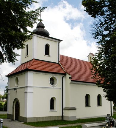 Zdjęcie nr 3: Kościół św. Jakuba Apostoła w Sance usytuowany jest na wzgórzu, w centrum wsi, na południe od głównej drogi. Teren przykościelny jest otoczony wysokim murem z wzniesionym na nim, niższym i żeliwnym płotem. W części północno-zachodniej muru zlokalizowana jest szeroka brama, od wschodu wąska furtka, a od południa wejście na cmentarz.

Kościół jest orientowany, murowany, otynkowany, jednonawowy z czworoboczną wieżą w fasadzie i z wąskim prezbiterium, zamkniętym półkoliście. Nawa jest szersza, na planie prostokąta, nakryta sklepieniem kolebkowym. Od zachodu do nawy dostawiona kruchta, a od strony północnej do prezbiterium zakrystia. W zachodniej części świątyni wzniesiony jest murowany chór muzyczny. Wnętrze bez zaznaczonych większych podziałów architektonicznych, jedynie w prezbiterium gzyms podokapowy, wychodzący na ścianę arkady tęczowej. Wnętrze oświetlają umieszczone w południowych ścianach nawy prostokątne, zamknięte półkoliście dwa okna oraz jedno od strony południowej w prezbiterium; ponadto niewielkie okrągłe okno na ścianie wschodniej prezbiterium. Do kościoła prowadzi główne wejście od strony zachodniej oraz jedno przez kruchtę od północy i dwa przez zakrystię. Zakrystia: wejście w części zachodniej zakończone ostrołukowo, nad nim okrągłe okno; drugie wejście w ścianie wschodniej, proste odrzwia; na ścianie północnej cztery prostokątne okna zakończone półkoliście.

W zewnętrznej elewacji kościoła widoczny jest niewysoki, kamienny cokół wyłożony płytami z piaskowca, powyżej kościół otynkowany. Świątynię obiega podokapowy gzyms. Prezbiterium, niższe od nawy. Nawa nakryta dachem dwuspadowym z trójkątnym szczytem schodkowym na wschodnim zakończeniu. Do zachodniej fasady kościoła dostawiona jest wysoka i masywna wieża, założona na planie kwadratu. W dolnej kondygnacji na osi kościoła prostokątne, zamknięte półkoliście wejście do kruchty. Narożniki pierwszej kondygnacji flankowane lizenami, ściany w dwóch trzecich wysokości przedzielone gzymsem, powyżej na każdej ściance okrągłe okna. Kondygnacje rozdzielone daszkiem. W drugiej kondygnacji narożniki ujęte lizenami, w polach prostokątne, półkoliście zamknięte wnęki okienne z żaluzjami. Wieża zwieńczona baniastym hełmem. Nawa nakryta dachem dwuspadowym, pokrytym czerwoną dachówką, prezbiterium dachem wielopołaciowym z blachy miedzianej, która pokrywa również zakrystię. W północną ścianę kruchty pod wieżą wbudowana jest tablica pamiątkowa poświęcona kapitanowi Stanisławowi Kwiatkowskiemu.
