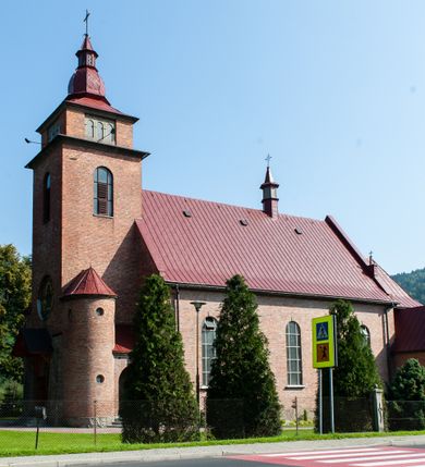 Zdjęcie nr 1: Kościół murowany, na kamiennym podmurowaniu, jednonawowy, na planie krzyża. Nawa na rzucie wydłużonego prostokąta, z węższym, jednoprzęsłowym prezbiterium zamkniętym trójbocznie, flankowanym dwoma kwadratowymi aneksami – zakrystią i kaplicą. Od południowego-zachodu dostawiona wieża na planie kwadratu z uskokowym zwężeniem ostatniej kondygnacji, z kruchtą w przyziemiu, ujęta dwiema wieżyczkami na planie ściętego koła, w południowej kręcone schody, w północnej schowek oraz dwoma otwartymi na zewnątrz arkadą aneksami na planie kwadratu z wejściami bocznymi do świątyni. Wnętrze nakryte sklepieniem kolebkowym z dwoma gurtami opadającymi na cztery półfilary. Otwór tęczowy w formie leżącego prostokąta zamkniętego łukiem półkolistym. W południowo-zachodniej części nawy zawieszony parapet chóru muzycznego o wybrzuszonej części środkowej balustrady. Posadzka betonowa, pokryta płytami kamiennymi. Fasada wieżowa, bez podziału na kondygnacje, w narożach ujęta kamiennymi szkarpami. Na osi portal wejściowy w formie kwadratu zamkniętego łukiem półkolistym, z dwuskrzydłowymi drzwiami, nakryty daszkiem okapowym. Nad nim okno witrażowe w formie koła. Wieża przepruta z trzech stron oknami w formie wydłużonego prostokąta zamkniętego półkoliście oraz w najwyższej części z czterech stron potrójnymi, arkadkowymi oknami. Wieżyczki przeprute niewielkimi, okrągłymi okienkami. Elewacje północna i południowa, ujęte we frontowych narożach kamiennymi szkarpami, przeprute trzema oknami witrażowymi w formie wydłużonego prostokąta zamkniętego półkoliście. Kaplica i zakrystia z jednym oknem o kształcie kwadratu zamkniętego łukiem półkolistym. Elewacja północno-wschodnia z dwoma oknami. Wieża nakryta dachem wieżowym kopulastym z latarnią zakończoną krzyżem, wieżyczki daszkami stożkowymi, a aneksy pulpitowymi. Dach nad nawą dwuspadowy z sześcioboczną wieżyczką na sygnaturkę nakrytą daszkiem wieżowym, prezbiterium niższe, przykryte dachem wielospadowym, kaplica i zakrystia dwuspadowym. 