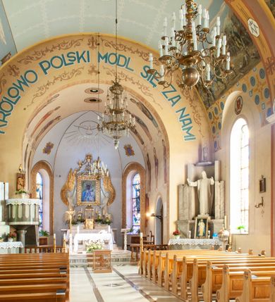 Zdjęcie nr 8: Kościół murowany, na kamiennym podmurowaniu, jednonawowy, na planie krzyża. Nawa na rzucie wydłużonego prostokąta, z węższym, jednoprzęsłowym prezbiterium zamkniętym trójbocznie, flankowanym dwoma kwadratowymi aneksami – zakrystią i kaplicą. Od południowego-zachodu dostawiona wieża na planie kwadratu z uskokowym zwężeniem ostatniej kondygnacji, z kruchtą w przyziemiu, ujęta dwiema wieżyczkami na planie ściętego koła, w południowej kręcone schody, w północnej schowek oraz dwoma otwartymi na zewnątrz arkadą aneksami na planie kwadratu z wejściami bocznymi do świątyni. Wnętrze nakryte sklepieniem kolebkowym z dwoma gurtami opadającymi na cztery półfilary. Otwór tęczowy w formie leżącego prostokąta zamkniętego łukiem półkolistym. W południowo-zachodniej części nawy zawieszony parapet chóru muzycznego o wybrzuszonej części środkowej balustrady. Posadzka betonowa, pokryta płytami kamiennymi. Fasada wieżowa, bez podziału na kondygnacje, w narożach ujęta kamiennymi szkarpami. Na osi portal wejściowy w formie kwadratu zamkniętego łukiem półkolistym, z dwuskrzydłowymi drzwiami, nakryty daszkiem okapowym. Nad nim okno witrażowe w formie koła. Wieża przepruta z trzech stron oknami w formie wydłużonego prostokąta zamkniętego półkoliście oraz w najwyższej części z czterech stron potrójnymi, arkadkowymi oknami. Wieżyczki przeprute niewielkimi, okrągłymi okienkami. Elewacje północna i południowa, ujęte we frontowych narożach kamiennymi szkarpami, przeprute trzema oknami witrażowymi w formie wydłużonego prostokąta zamkniętego półkoliście. Kaplica i zakrystia z jednym oknem o kształcie kwadratu zamkniętego łukiem półkolistym. Elewacja północno-wschodnia z dwoma oknami. Wieża nakryta dachem wieżowym kopulastym z latarnią zakończoną krzyżem, wieżyczki daszkami stożkowymi, a aneksy pulpitowymi. Dach nad nawą dwuspadowy z sześcioboczną wieżyczką na sygnaturkę nakrytą daszkiem wieżowym, prezbiterium niższe, przykryte dachem wielospadowym, kaplica i zakrystia dwuspadowym. 