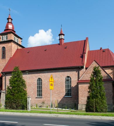 Zdjęcie nr 2: Kościół murowany, na kamiennym podmurowaniu, jednonawowy, na planie krzyża. Nawa na rzucie wydłużonego prostokąta, z węższym, jednoprzęsłowym prezbiterium zamkniętym trójbocznie, flankowanym dwoma kwadratowymi aneksami – zakrystią i kaplicą. Od południowego-zachodu dostawiona wieża na planie kwadratu z uskokowym zwężeniem ostatniej kondygnacji, z kruchtą w przyziemiu, ujęta dwiema wieżyczkami na planie ściętego koła, w południowej kręcone schody, w północnej schowek oraz dwoma otwartymi na zewnątrz arkadą aneksami na planie kwadratu z wejściami bocznymi do świątyni. Wnętrze nakryte sklepieniem kolebkowym z dwoma gurtami opadającymi na cztery półfilary. Otwór tęczowy w formie leżącego prostokąta zamkniętego łukiem półkolistym. W południowo-zachodniej części nawy zawieszony parapet chóru muzycznego o wybrzuszonej części środkowej balustrady. Posadzka betonowa, pokryta płytami kamiennymi. Fasada wieżowa, bez podziału na kondygnacje, w narożach ujęta kamiennymi szkarpami. Na osi portal wejściowy w formie kwadratu zamkniętego łukiem półkolistym, z dwuskrzydłowymi drzwiami, nakryty daszkiem okapowym. Nad nim okno witrażowe w formie koła. Wieża przepruta z trzech stron oknami w formie wydłużonego prostokąta zamkniętego półkoliście oraz w najwyższej części z czterech stron potrójnymi, arkadkowymi oknami. Wieżyczki przeprute niewielkimi, okrągłymi okienkami. Elewacje północna i południowa, ujęte we frontowych narożach kamiennymi szkarpami, przeprute trzema oknami witrażowymi w formie wydłużonego prostokąta zamkniętego półkoliście. Kaplica i zakrystia z jednym oknem o kształcie kwadratu zamkniętego łukiem półkolistym. Elewacja północno-wschodnia z dwoma oknami. Wieża nakryta dachem wieżowym kopulastym z latarnią zakończoną krzyżem, wieżyczki daszkami stożkowymi, a aneksy pulpitowymi. Dach nad nawą dwuspadowy z sześcioboczną wieżyczką na sygnaturkę nakrytą daszkiem wieżowym, prezbiterium niższe, przykryte dachem wielospadowym, kaplica i zakrystia dwuspadowym. 