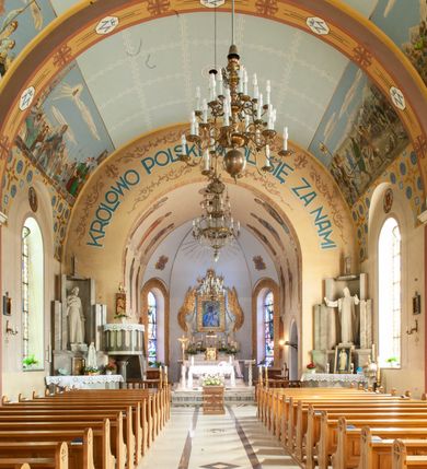 Zdjęcie nr 6: Kościół murowany, na kamiennym podmurowaniu, jednonawowy, na planie krzyża. Nawa na rzucie wydłużonego prostokąta, z węższym, jednoprzęsłowym prezbiterium zamkniętym trójbocznie, flankowanym dwoma kwadratowymi aneksami – zakrystią i kaplicą. Od południowego-zachodu dostawiona wieża na planie kwadratu z uskokowym zwężeniem ostatniej kondygnacji, z kruchtą w przyziemiu, ujęta dwiema wieżyczkami na planie ściętego koła, w południowej kręcone schody, w północnej schowek oraz dwoma otwartymi na zewnątrz arkadą aneksami na planie kwadratu z wejściami bocznymi do świątyni. Wnętrze nakryte sklepieniem kolebkowym z dwoma gurtami opadającymi na cztery półfilary. Otwór tęczowy w formie leżącego prostokąta zamkniętego łukiem półkolistym. W południowo-zachodniej części nawy zawieszony parapet chóru muzycznego o wybrzuszonej części środkowej balustrady. Posadzka betonowa, pokryta płytami kamiennymi. Fasada wieżowa, bez podziału na kondygnacje, w narożach ujęta kamiennymi szkarpami. Na osi portal wejściowy w formie kwadratu zamkniętego łukiem półkolistym, z dwuskrzydłowymi drzwiami, nakryty daszkiem okapowym. Nad nim okno witrażowe w formie koła. Wieża przepruta z trzech stron oknami w formie wydłużonego prostokąta zamkniętego półkoliście oraz w najwyższej części z czterech stron potrójnymi, arkadkowymi oknami. Wieżyczki przeprute niewielkimi, okrągłymi okienkami. Elewacje północna i południowa, ujęte we frontowych narożach kamiennymi szkarpami, przeprute trzema oknami witrażowymi w formie wydłużonego prostokąta zamkniętego półkoliście. Kaplica i zakrystia z jednym oknem o kształcie kwadratu zamkniętego łukiem półkolistym. Elewacja północno-wschodnia z dwoma oknami. Wieża nakryta dachem wieżowym kopulastym z latarnią zakończoną krzyżem, wieżyczki daszkami stożkowymi, a aneksy pulpitowymi. Dach nad nawą dwuspadowy z sześcioboczną wieżyczką na sygnaturkę nakrytą daszkiem wieżowym, prezbiterium niższe, przykryte dachem wielospadowym, kaplica i zakrystia dwuspadowym. 