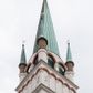 Zdjęcie nr 1: Kościół orientowany, murowany, trójnawowy, z prezbiterium zamkniętym trójbocznie, zakrystią od północy i kruchtą od południa. Do naw przylegają kaplice: większa od północy i mniejsza od południa. Dwie kolejne kaplice przylegają do boków wieży. Ściany wnętrza gładkie, pokryte polichromią imitującą podziały i obramienia, dekorację ornamentalną i sceny iluzjonistyczne na stropach, utrzymane w chłodnej biało-niebiesko-różowej tonacji z dodatkiem żółtego. Na stropie prezbiterium scena Zwiastowania, na stropie nawy Zesłania Ducha Świętego. Od zachodu chór muzyczny wsparty na dwóch filarach z balustradą pokrytą polichromią. Prezbiterium i nawa główna nakryte stropami, nad prezbiterium o przekroju spłaszczonej kolebki, nad nawą płaski, z szerokimi fasetami, zakrystia sklepiona kolebkowo, kruchta i kaplice wschodnie krzyżowo. Nawę, prezbiterium i część kaplic doświetlają okna w kształcie stojącego prostokąta zamkniętego łukiem pełnym, pozostałe zamknięte łukiem odcinkowym lub kwadratowe. Główne wejście i dwa boczne od zachodu, kolejne do przedsionka od północy i do kruchty od południa. Fasada z wieżą na osi, poprzedzona portykiem wspartym na filarach, z trójkątnym szczytem zwieńczonym krzyżem łacińskim. Fasada jednokondygnacyjna, przechodząca w masyw wieży. Kondygnację przepruwają trzy okna i jest zamknięta gzymsem wyniesionym na środku w łuk. Wieńczący ją trójkątny szczyt wtapia się w kondygnację wieży o gładkich elewacjach przeprutych jedynie niewielkimi oknami i tarczami zegarów. Ostatnia kondygnacja jest ujęta gzymsami i dekorowana fryzem arkadowym, którego arkady wykonano z nietynkowanej cegły. Zwieńczenie rozbudowane składa się z iglicy i ustawionych wokół niej, w narożach małych, dwukondygnacyjnych wieżyczek zamkniętych dachami stożkowymi. Wieżyczki połączono podwójnymi arkadami, których łuki wykonano z nietynkowanej cegły, tak samo jak górne kondygnacje wieżyczek. Elewacje kościoła gładkie, na niskim, kamiennym cokole, od wschodu opięte szkarpami. Prezbiterium i nawę przekrywają osobne dachy dwuspadowe, na kalenicy nawy wieżyczka na sygnaturkę, cztery kaplice i portyk nakrywają dachy trójpołaciowe, zakrystię i nawy boczne pulpitowe. 
Jedyne zachowane elementy wyposażenia sprzed pożaru w 1815 roku to fragment osiemnastowiecznej polichromii przedstawiającej dwóch aniołów z narzędziami męki i przedmioty nawiązujące do tego wydarzenia oraz gotycki portal do zakrystii wraz z żelaznymi, kutymi drzwiami. 
