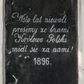 Zdjęcie nr 1: Tablica w kształcie stojącego prostokąta z bieloną inskrypcją „Wsto lat niewoli / prosimy ze łzami / Królowo Polski / módl się za nami ! / 1896”. 