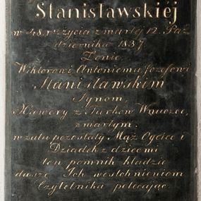 Zdjęcie nr 1: Kamienna płyta w kształcie stojącego prostokąta z wykutą i pozłoconą inskrypcją „D(EO) O(PTIMO) M(AXIMO) / Possesorce Rzozowa / Zofii z Mendelowiczów / Stanisławskiej / w 48. r(ok)u życia zmarłej 12. Paź/dziernika 1837. / Żonie, / Wiktorowi, Antoniemu, Józefowi / Stanisławskim / Synom, / Xawery z Turków Wnuczce, / zmarłym. / w żalu pozostały Mąż Oyciec i / Dziadek z dziećmi / ten pomnik kładzie / duszę Ich westchnieniom / Czytelnika polecając”. Napis obwiedziono ramką wyciętą w narożach, aby zrobić miejsce na dekoracyjne rozetki. 