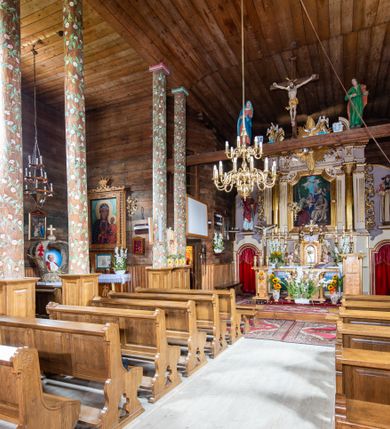 Zdjęcie nr 4: Kościół św. Joachima w Skawinkach usytuowany jest w centrum wsi, na zachód od głównej drogi prowadzącej z Palczy do Kalwarii Zebrzydowskiej. Teren przykościelny jest usytuowany na wysokim wzniesieniu, do którego prowadzą trzy wejścia, jedno przez schody, drugie przez obszerny wjazd od strony południowej.

Kościół skierowany na zachód, drewniany o konstrukcji zrębowej, na rzucie krzyża greckiego ze ściętymi kątami międzyramiennymi.  Przy prezbiterium zakrystia. Strop wsparty na czterech parach słupów, ustawionych w krzyżu kościoła, w licu ścian ramienia wschodniego i zachodniego. Belka tęczy prosta, profilowana na kroksztynach, na niej Grupa Ukrzyżowania. Świątynia połączona za pomocą kruchty z wieżą o konstrukcji słupowej, na planie kwadratu z nadwieszoną izbicą, nakryta dachem namiotowym, ściany dzwonnicy opasane mniej więcej w połowie wysokości pulpitowym daszkiem, zlewającym się po bokach z siodłowym dachem kruchty. Do kościoła prowadzi główne wejście w przedsionku od strony południowej. Wnętrze świątyni oświetlają prostokątne okna. Dach nakryty gontem, na skrzyżowaniu ramiona krzyża greckiego wystawiona wieżyczka na sygnaturkę z latarnią. Ściany na zewnątrz pokryte szalunkiem pionowym.
