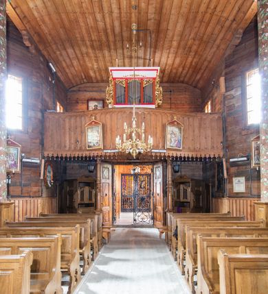 Zdjęcie nr 6: Kościół św. Joachima w Skawinkach usytuowany jest w centrum wsi, na zachód od głównej drogi prowadzącej z Palczy do Kalwarii Zebrzydowskiej. Teren przykościelny jest usytuowany na wysokim wzniesieniu, do którego prowadzą trzy wejścia, jedno przez schody, drugie przez obszerny wjazd od strony południowej.

Kościół skierowany na zachód, drewniany o konstrukcji zrębowej, na rzucie krzyża greckiego ze ściętymi kątami międzyramiennymi.  Przy prezbiterium zakrystia. Strop wsparty na czterech parach słupów, ustawionych w krzyżu kościoła, w licu ścian ramienia wschodniego i zachodniego. Belka tęczy prosta, profilowana na kroksztynach, na niej Grupa Ukrzyżowania. Świątynia połączona za pomocą kruchty z wieżą o konstrukcji słupowej, na planie kwadratu z nadwieszoną izbicą, nakryta dachem namiotowym, ściany dzwonnicy opasane mniej więcej w połowie wysokości pulpitowym daszkiem, zlewającym się po bokach z siodłowym dachem kruchty. Do kościoła prowadzi główne wejście w przedsionku od strony południowej. Wnętrze świątyni oświetlają prostokątne okna. Dach nakryty gontem, na skrzyżowaniu ramiona krzyża greckiego wystawiona wieżyczka na sygnaturkę z latarnią. Ściany na zewnątrz pokryte szalunkiem pionowym.
